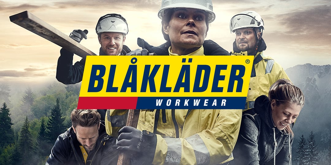Fem personer i gula och svarta arbetsjackor och skyddsutrustning står utanför med verktyg, med Blåkläder Workwears logotyp i mitten.