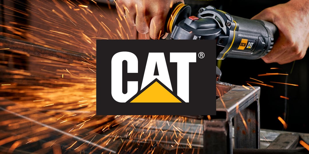 Noen bruker en CAT vinkelsliper på metall, og det slår gnister, med CAT-logoen tydelig plassert i midten av bildet.