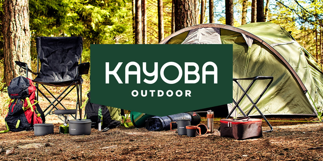 Vihreä teltta, retkeilytuoleja, reppuja ja keittovälineitä mäntymetsässä. Tummanvihreässä laatikossa lukee KAYOBA OUTDOOR lihavoidulla valkoisella tekstillä.
