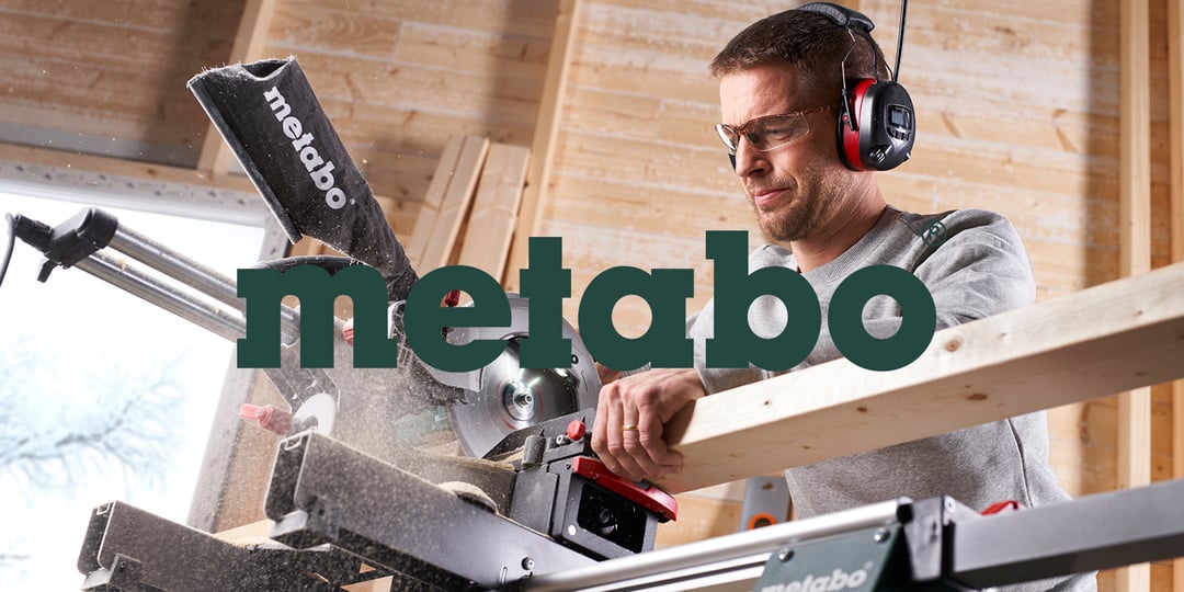 En man med skyddsglasögon och hörselkåpor använder en Metabo kap- och geringssåg för att såga trä i en verkstad, Metabos logotyp syns på bilden.