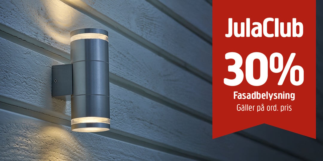 En elegant utomhusvägglampa i rostfritt stål på träfasaden. På en röd banderoll till höger står det: JulaClub 30 % Fasadbelysning Gäller på ord. pris.