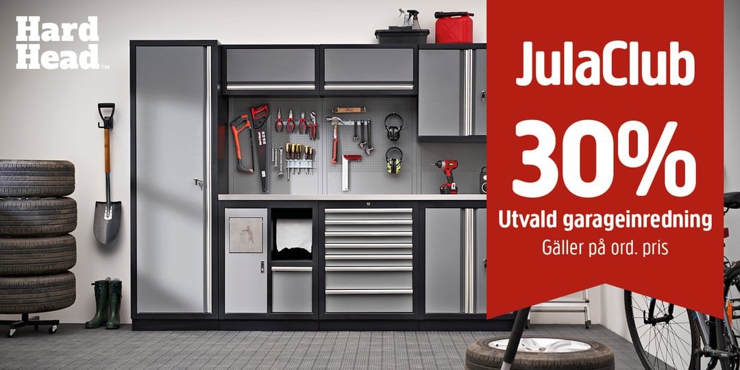 Ett välordnat garage med förvaringsskåp, verktyg upphängda på väggarna, däck till vänster och en röd skylt till höger som erbjuder 30 % rabatt på garageutrustning.