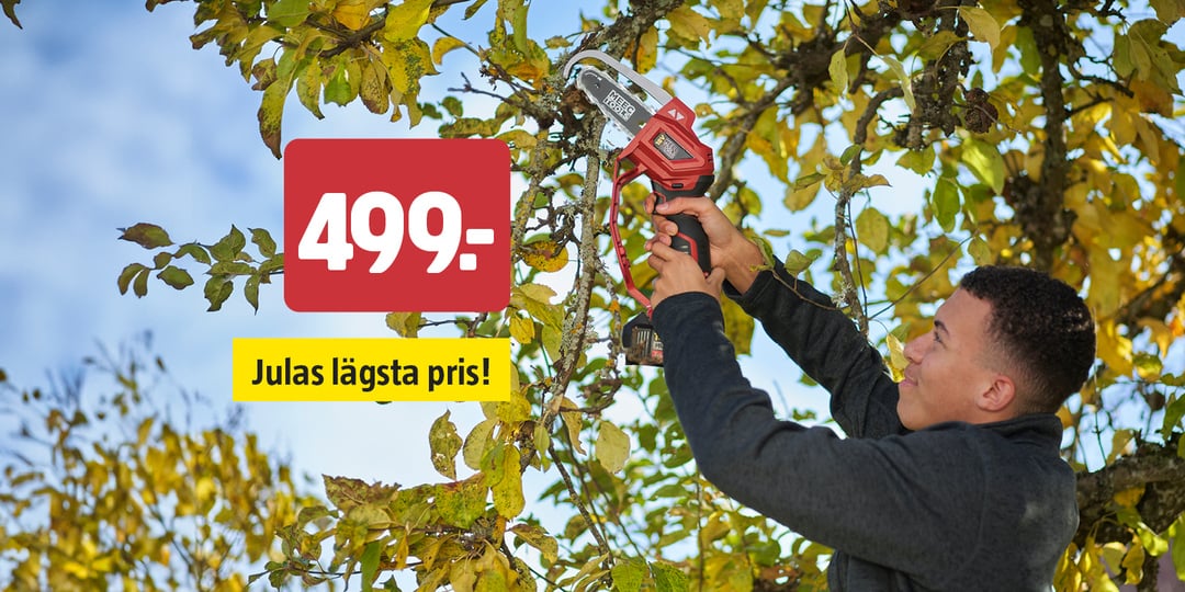 En person kapar en trädgren med hjälp av en röd och svart elektrisk beskärningssåg. På en röd prislapp står det 499:-, och på en gul etikett står det ”Julas lägsta pris!”. Trädet har gröna och gula blad.