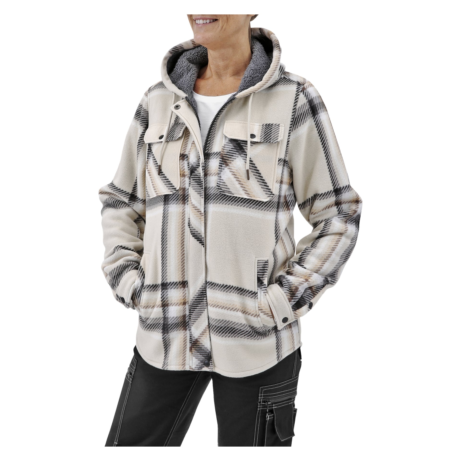 Henkilö näkyy vyötäröstä ylöspäin, hymyilevä kädet taskuissa, pukeutuneena Bluewear Womanin Milly-fleecetakkiin, jossa on vaaleanbeige ja harmaa ruudullinen kuvio. Takissa on huppu, läppätaskut, etunapit ja nyörit, jotka on kerrostettu valkoisen paidan päälle.