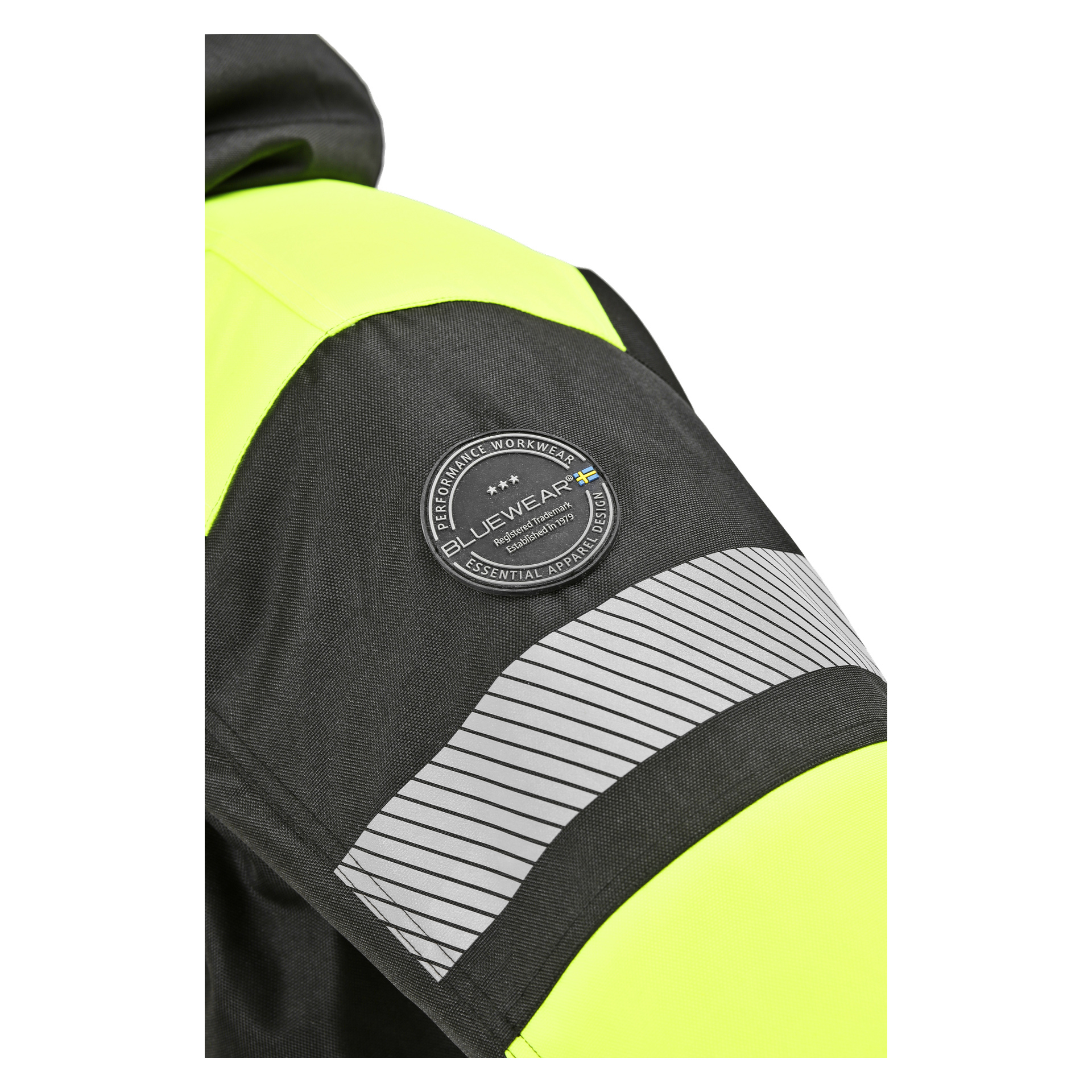 Detaljerad vy av Bluewear Parka-ärmen visar reflekterande detaljer, inklusive en framträdande reflekterande rand och en cirkulär Bluewear-lapp med texten Performance Workwear Essential Apparel. Jackan har svarta och neongula färger.