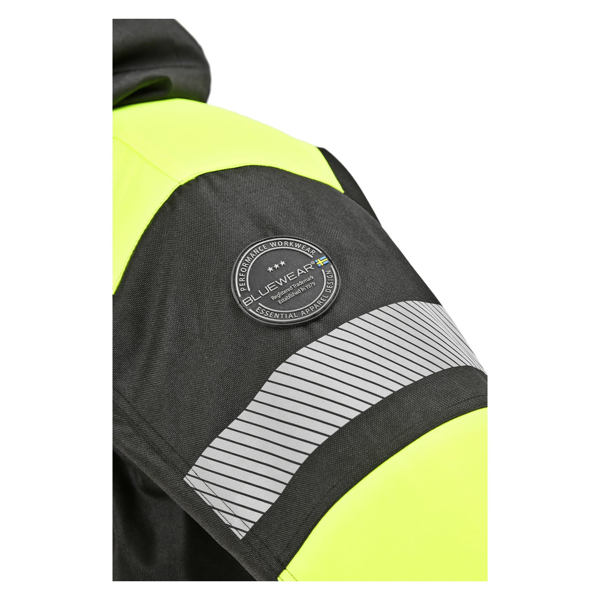 En detaljerad vy av Bluewear-parkasan i svart och neongult, med en rund Bluewear-badge som visar en liten svensk flagga och en reflekterande silverremsa på ärmen.