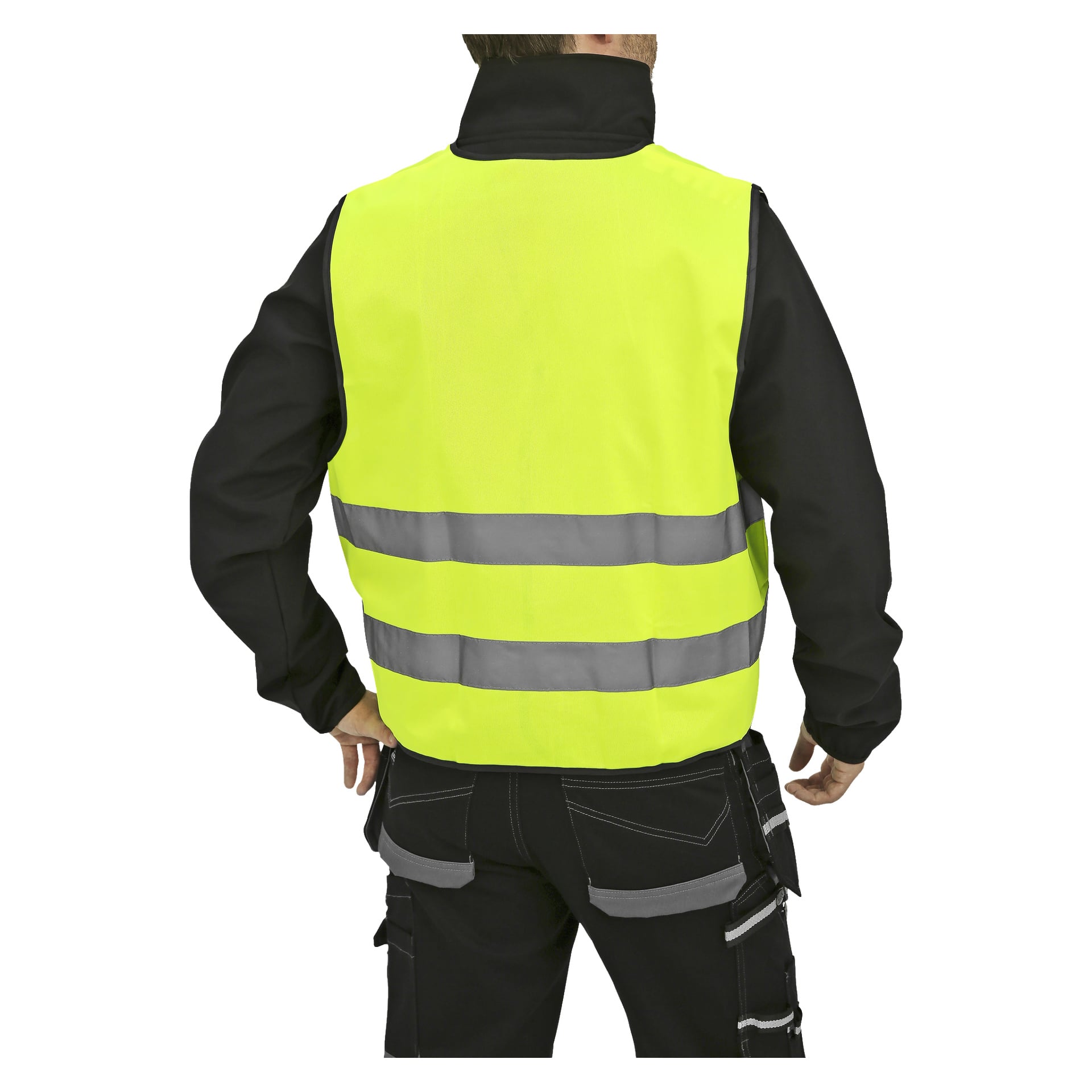 En person står med ryggen til kameraet, kledd i en Bluewear Reflective tabard—en knallgul høysynlig vest med to horisontale refleksstriper—som bæres over en svart jakke og svarte arbeidsbukser med grå lommer og stropper.