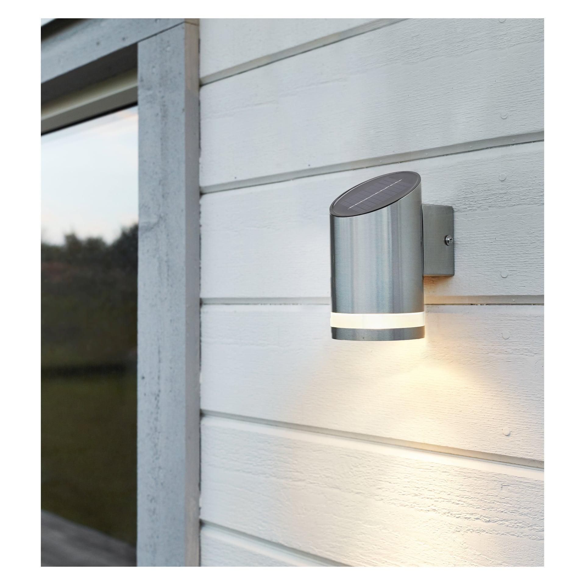 Anslut Wall -lamppu LED, jossa on metallipinta, on asennettu vaakasuoralle verhoukselle ja valaistu. Vasemmalla näkyy ikkuna.