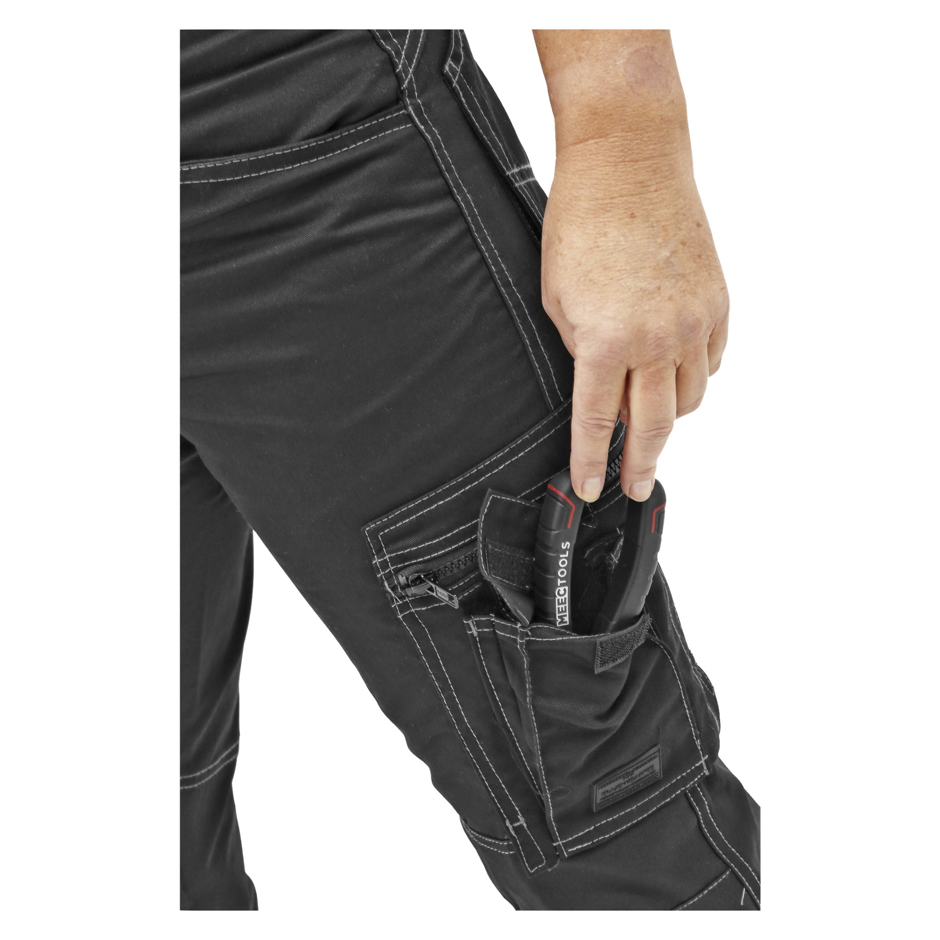 Eine Hand legt oder entfernt ein NEBO Tools-Gerät aus der Seitentasche der Bluewear Damenarbeitshosen mit weißer Naht und mehreren Reißverschluss- und Klappentaschen.