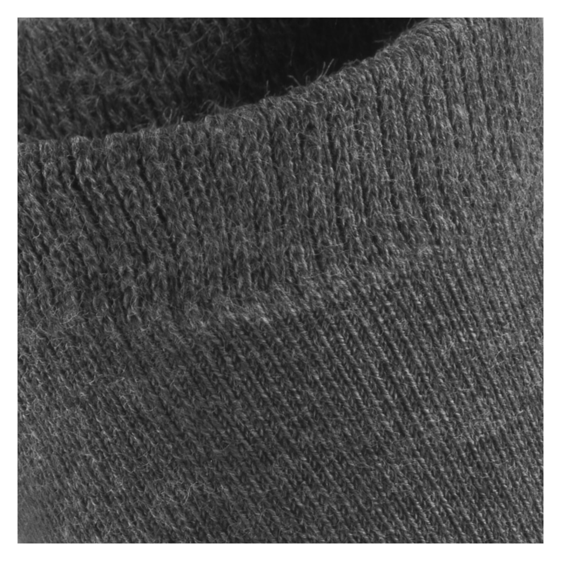 Lähikuvassa näkyy paksun, tummanharmaan sukan teksturoitu kalvosin Bluewear Children's Socks 5 parista, keskittyen yksityiskohtaiseen kudokseen ja kuituihin.