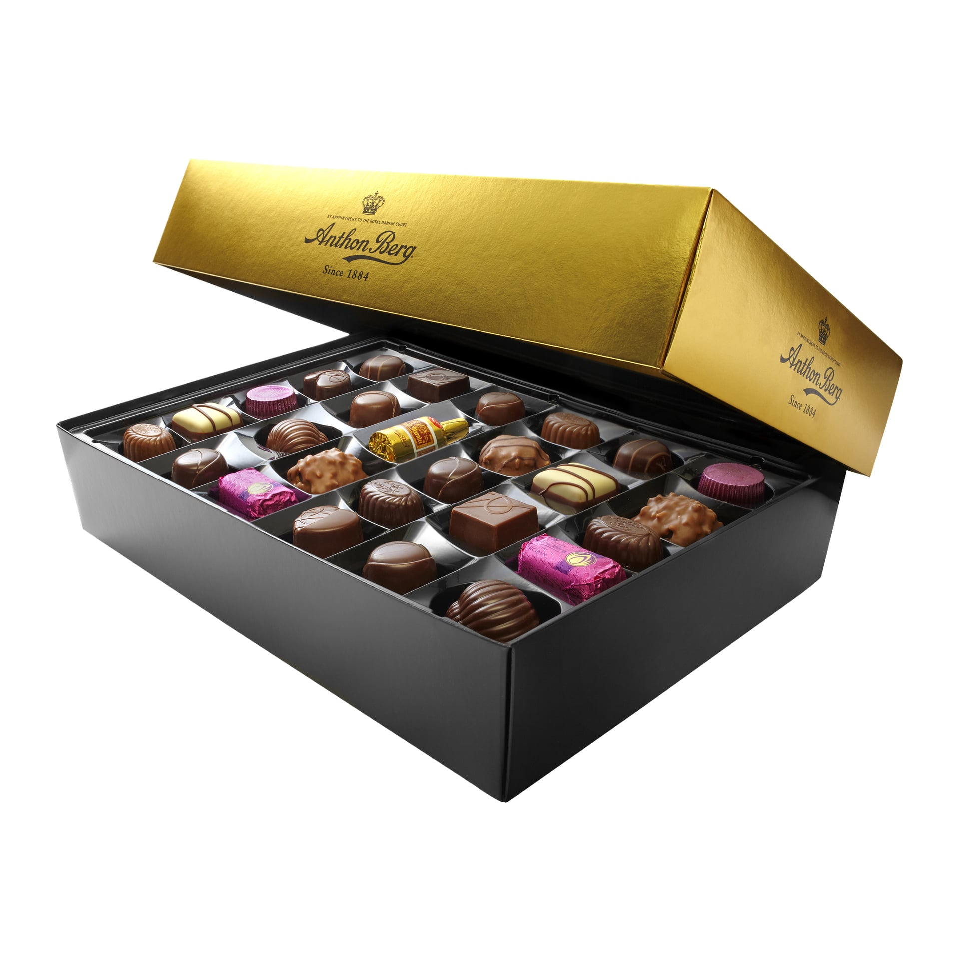 En öppen Anthon Berg-chokladask visar prydliga rader av olika chokladbitar i en plastbricka, med det guld- och svarta locket uppstött för att avslöja sötsakerna inuti. Lådan har namnet Anthon Berg.