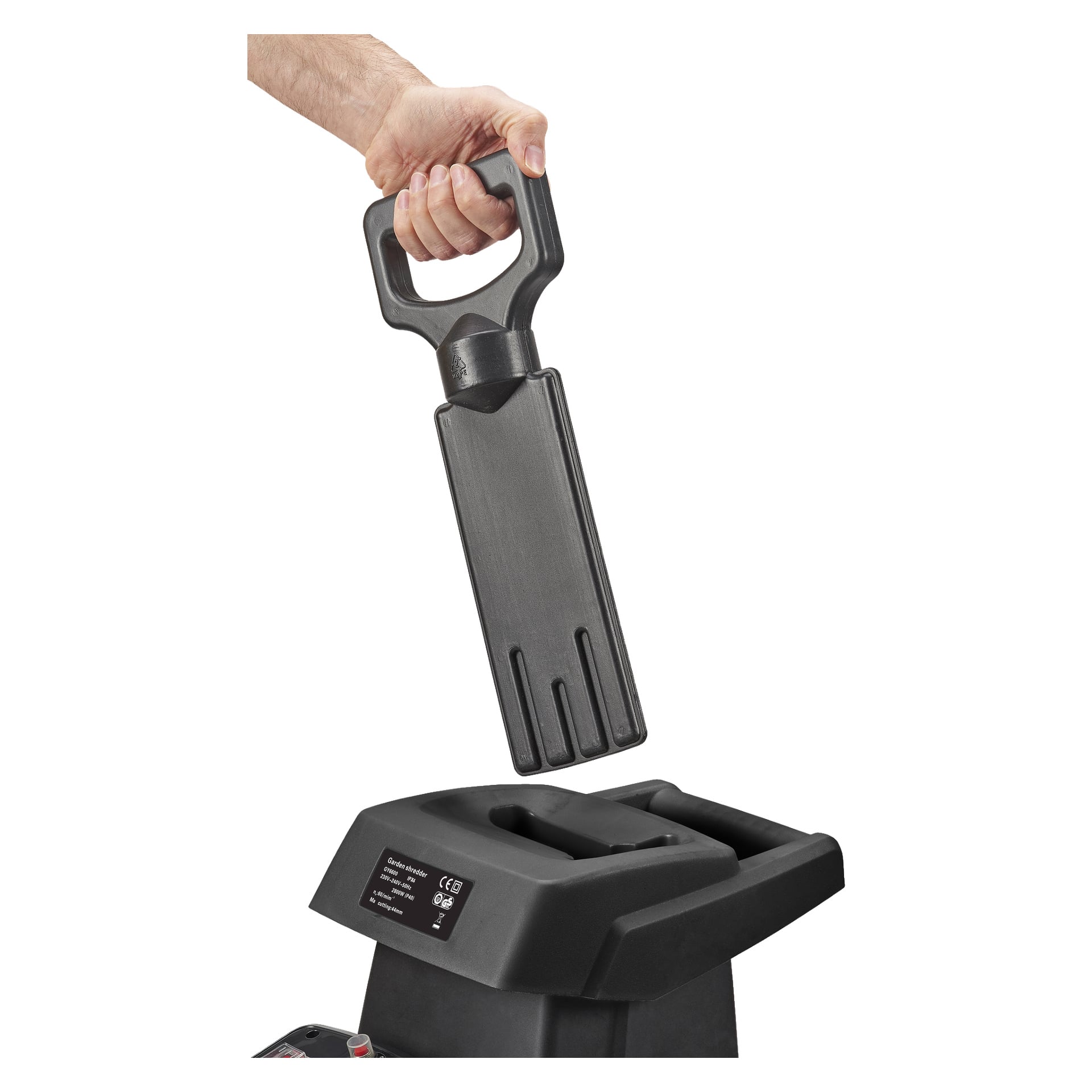 En hånd holder en svart plastpadle over sporet på en svart Meec Tools kompostmakulator, klar til å sette den inn. Makulatoren har en etikett og knapper på forsiden.