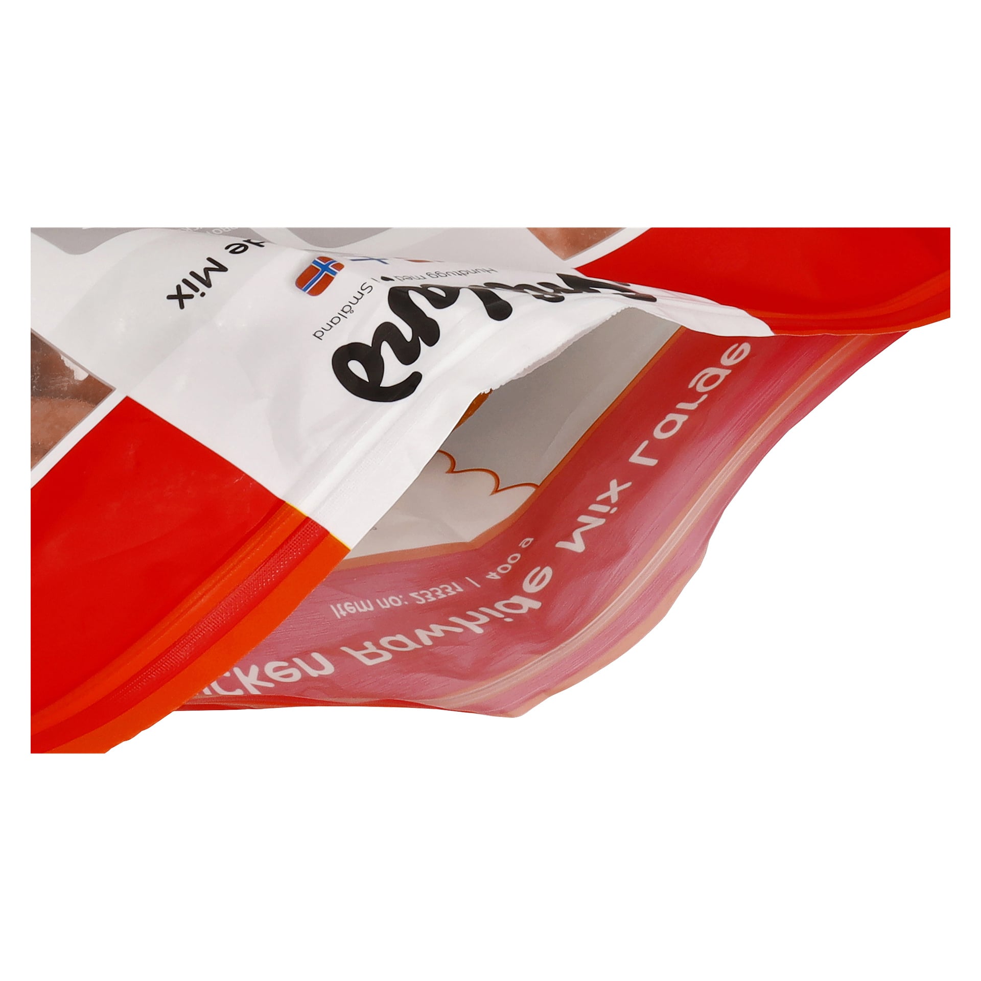 Närbild på ett Småland Chewing Bene-paket med en orange dragkedjasförsegling och synlig text på en rödvit påse.