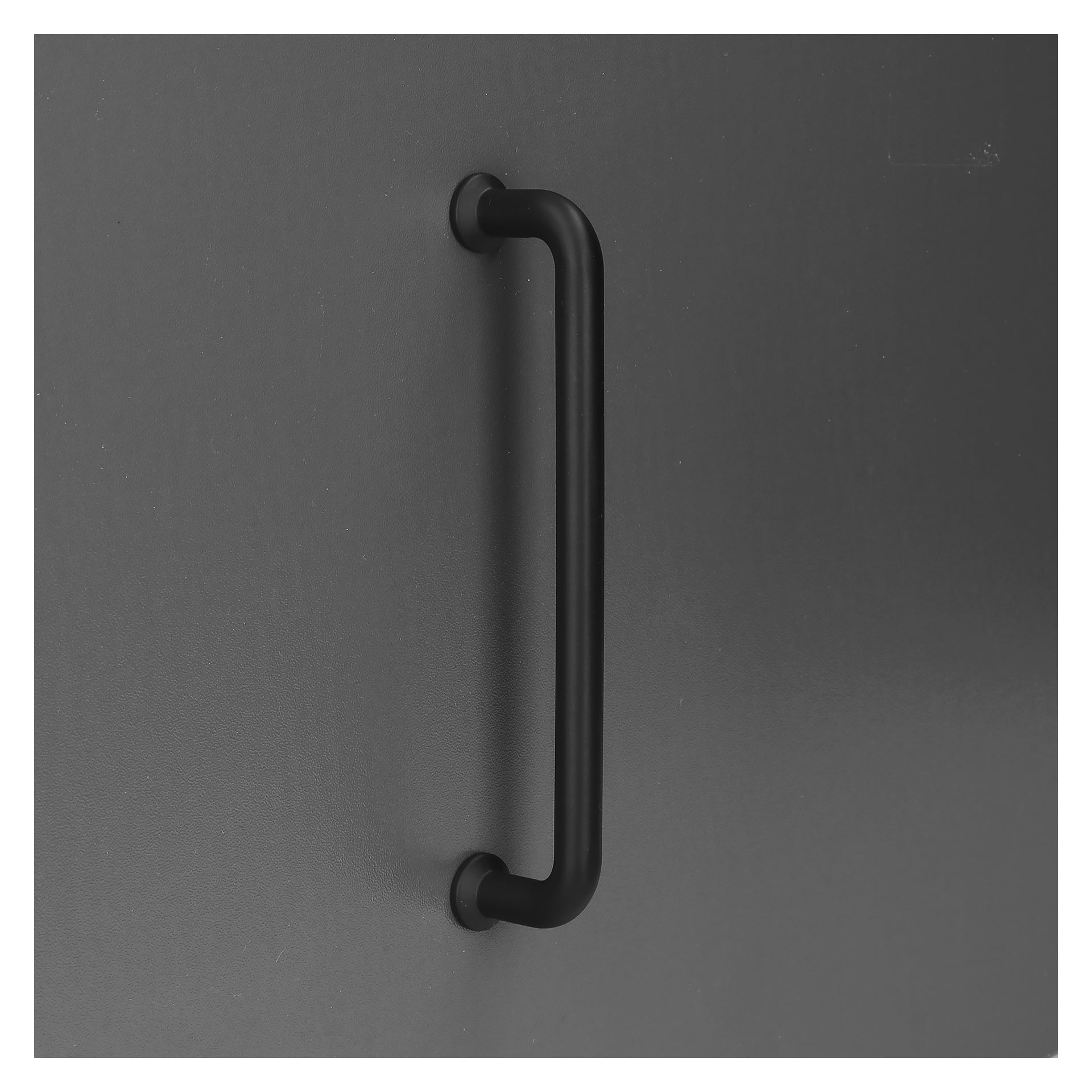 Ein Paar schwarze Hard Head Schrankgriffe sind vertikal auf einer schlanken, dunkelgrauen Oberfläche angebracht. Jeder mattschwarze Metallstiel hat weich abgerundete Kanten und ist an beiden Enden mit runden Halterungen befestigt.