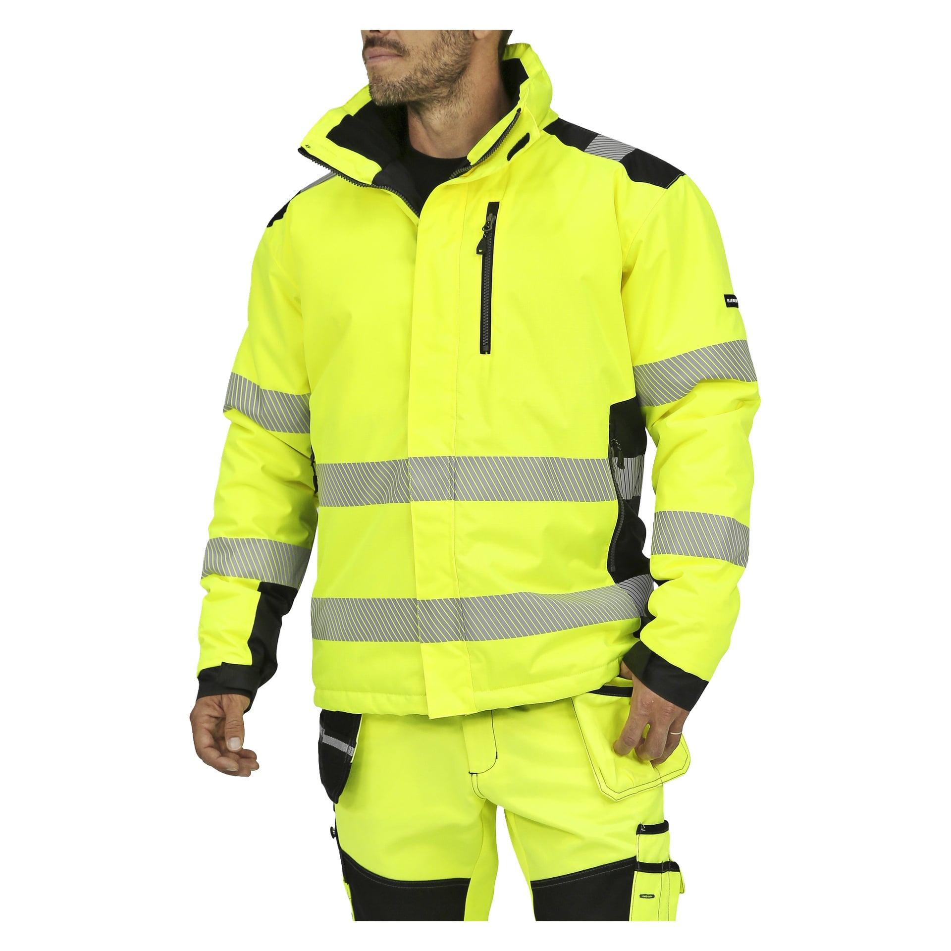 Eine Person, die die Bluewear Warm-lined Hi-Vis-Jacke und -hose trägt, gekennzeichnet durch leuchtend gelben, hochsichtbaren Stoff mit reflektierenden Streifen und schwarzen Details an Schultern und Knien, steht vor einem schlichten Hintergrund.