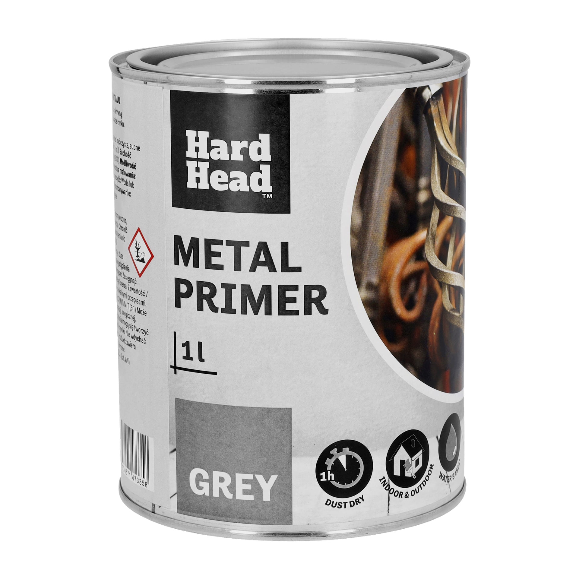 Wystawiona jest szara, jednolitrowa puszka Hard Head Metal Primer. Etykieta pokazuje ikony suszenia kurzu w ciągu godziny i stosowania wewnątrz lub na zewnątrz. Zardzewiałe metalowe obiekty są częściowo widoczne na zdjęciu tła.