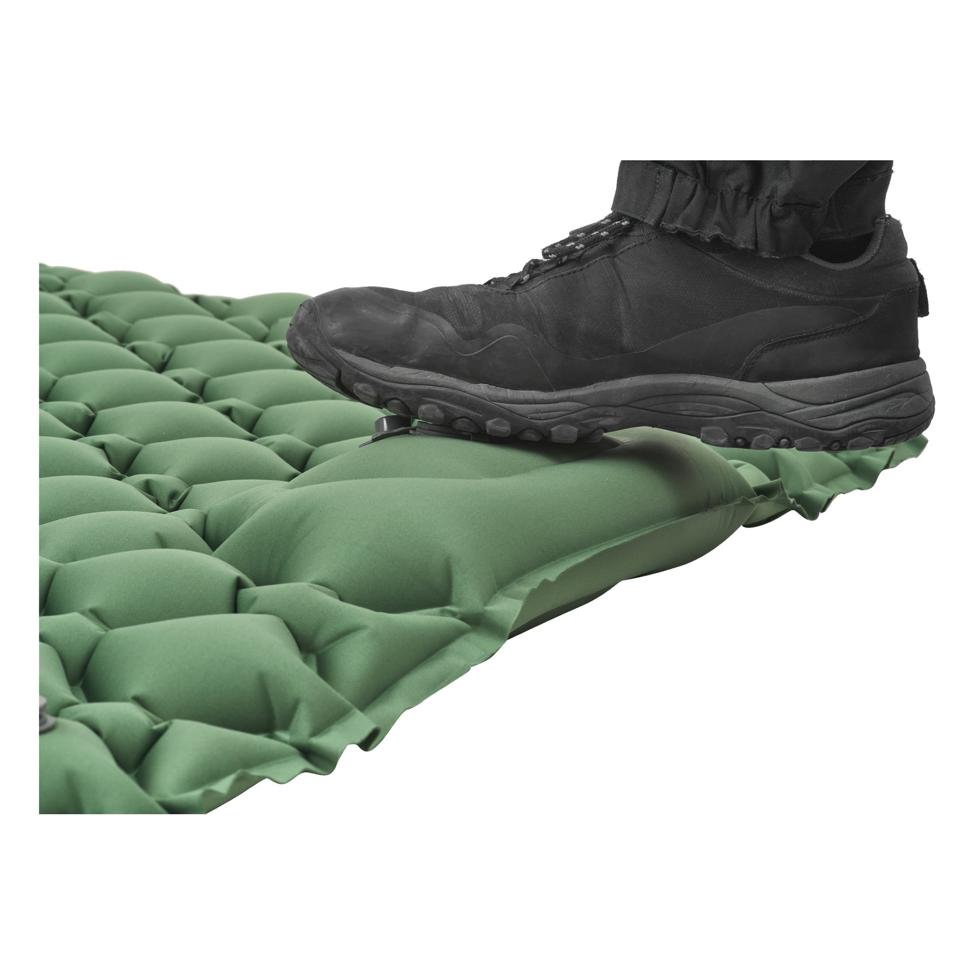 Ein schwarzer Stiefel drückt auf die grüne Kayoba-Schlafmatte und drückt sie sichtbar zusammen, um die Stärke und Luftspeicherung der Matte zu demonstrieren.