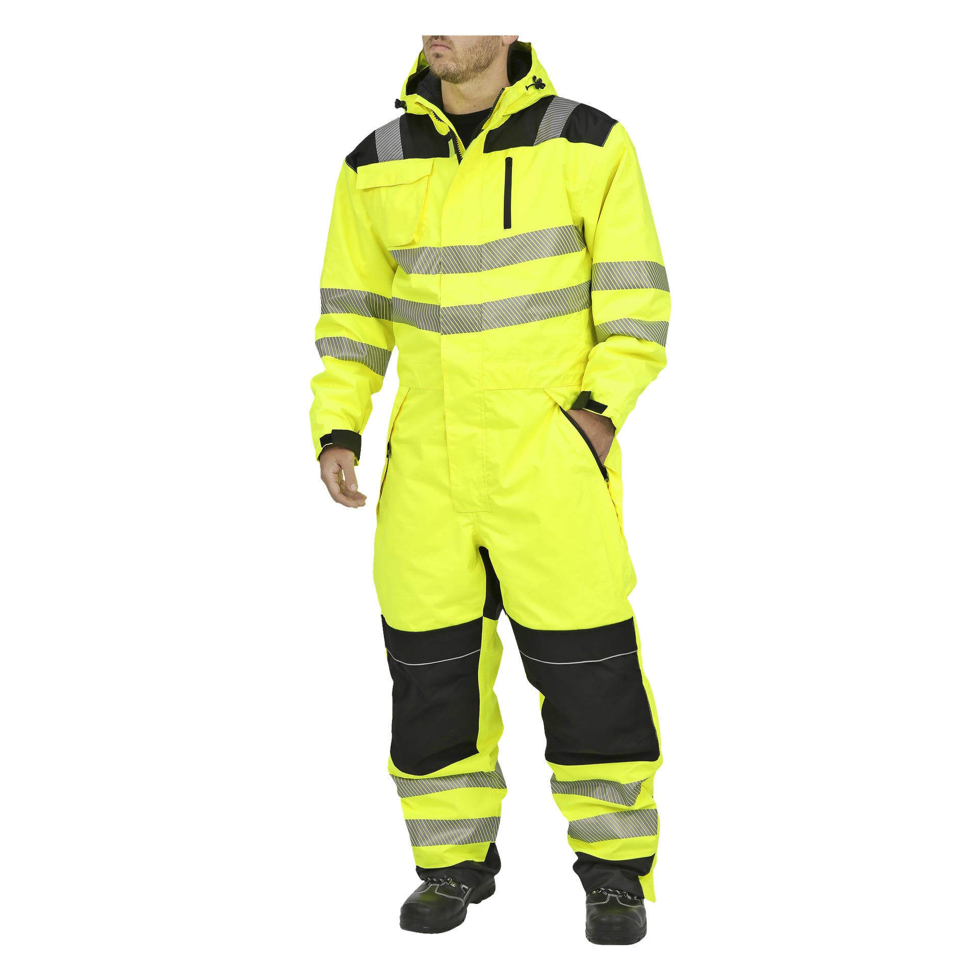 En person står med ena handen i fickan, klädd i gult och svart Bluewear högsynliga overaller med reflekterande ränder, huva och svarta skor.