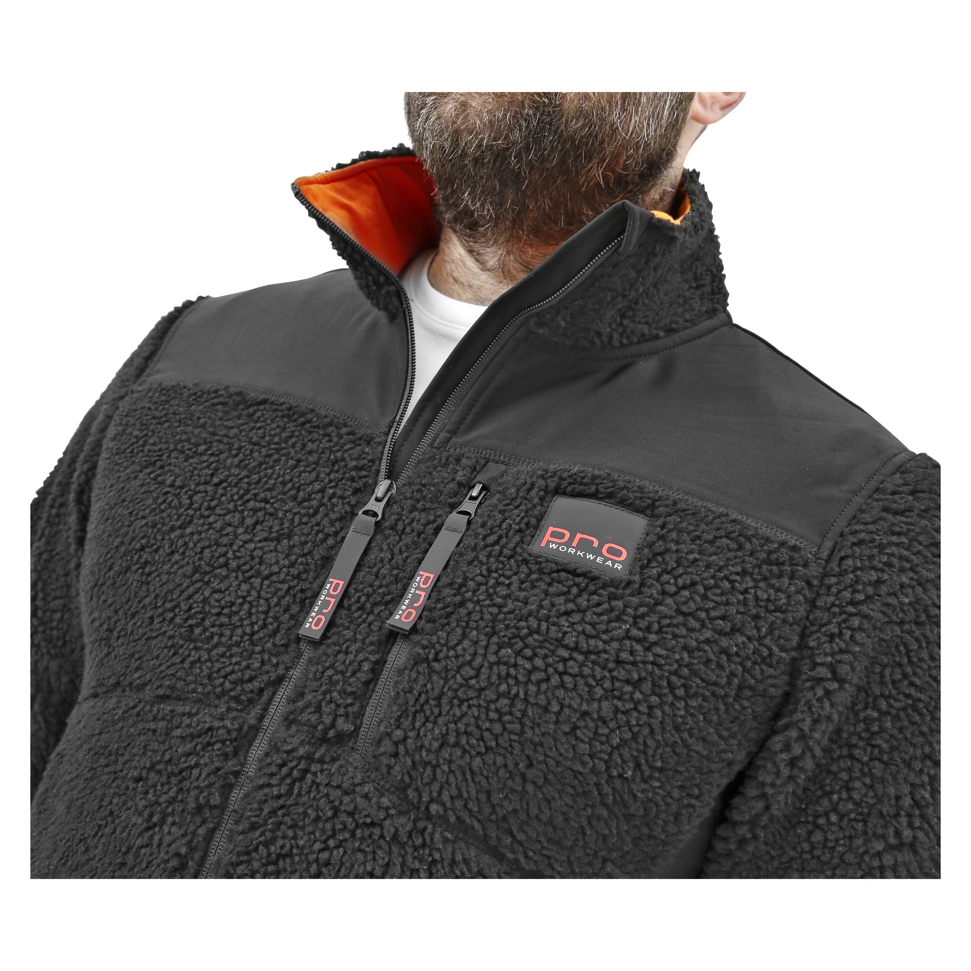En skäggig man visar en svart herrfiberpälsjacka från Bluewear Pro Workwear, som har hög krage, orange foder, två dragkedjefickor på bröstet och visar PNQ Workwear-logotypen.