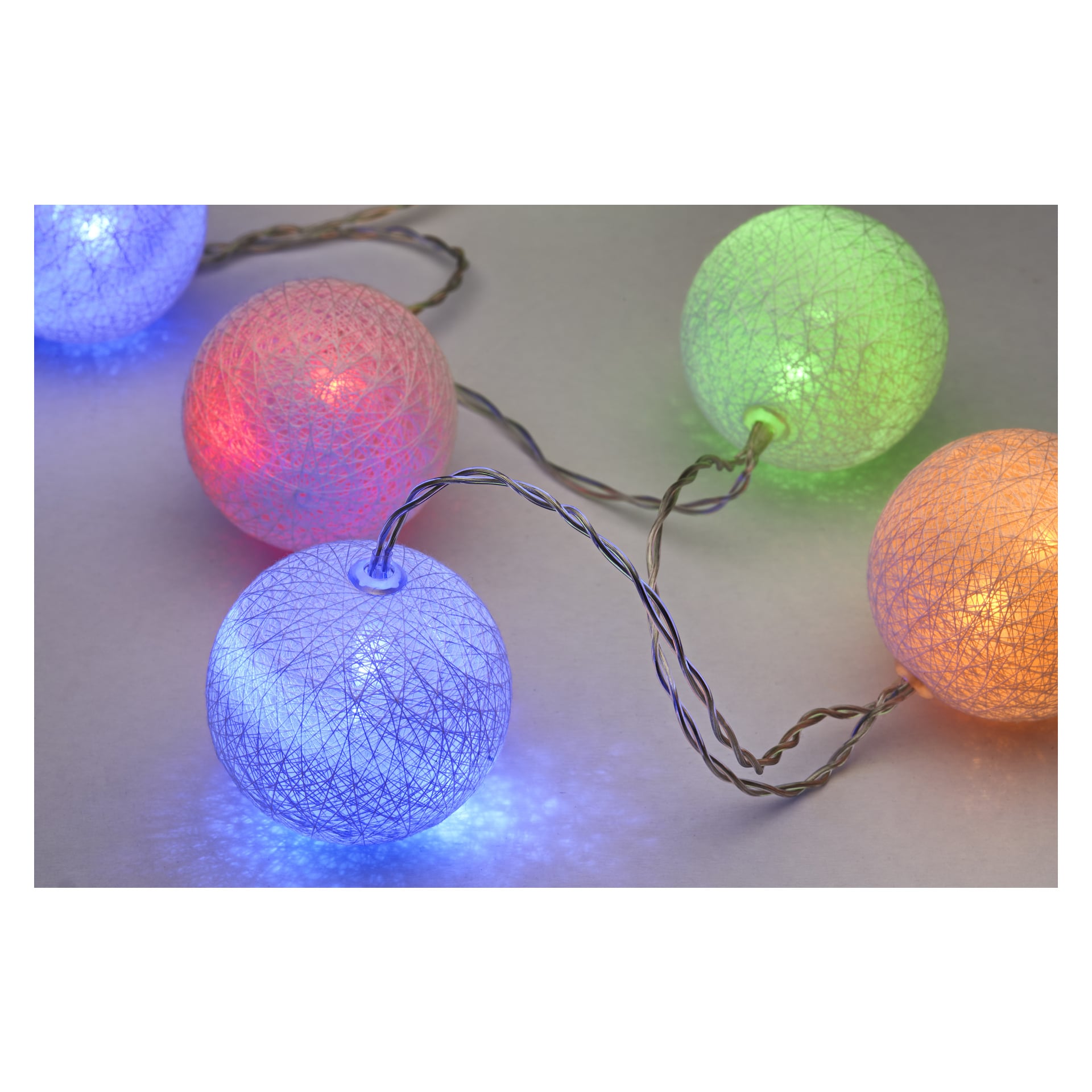 EKVIP LED-ljusslingor med runda, vävda skydd i blått, rosa, grönt, gult och orange är arrangerade på en ljus yta. De lysande lamporna är sammanlänkade med genomskinliga ledningar.