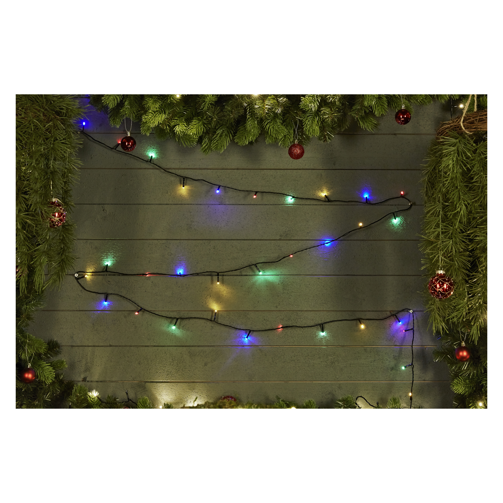 EKVIP batteriebetriebene LED-Lichter sind an einer grauen Holzwand aufgehängt, akzentuiert von üppig grünen Kieferngirlanden und roten Ornamenten für einen festlichen Look.
