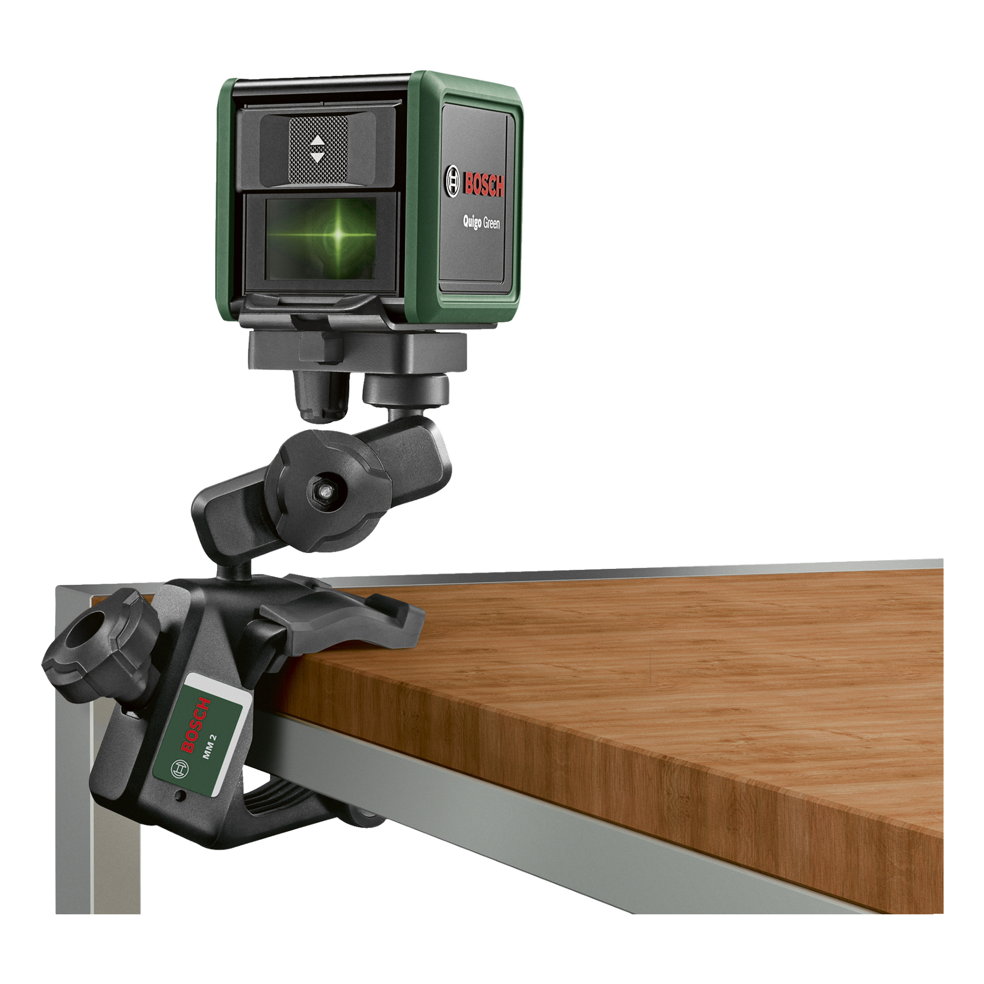 Et Bosch Quigo grønt laservater klemmes fast til kanten av et trebord ved hjelp av en Bosch MM2 universalklemme, og sender ut en levende grønn horisontal laserlinje.