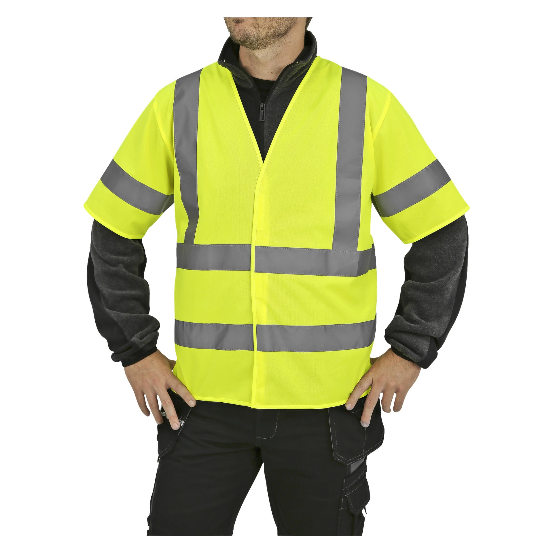 Osoba z rękami na biodrach lekko odwrócona w lewo, ubrana w żółtą kamizelkę Bluewear Reflective z szarymi paskami odblaskowymi na czarnej kurtce i spodniach. Górna część ich twarzy jest częściowo poza zasięgiem wzroku.