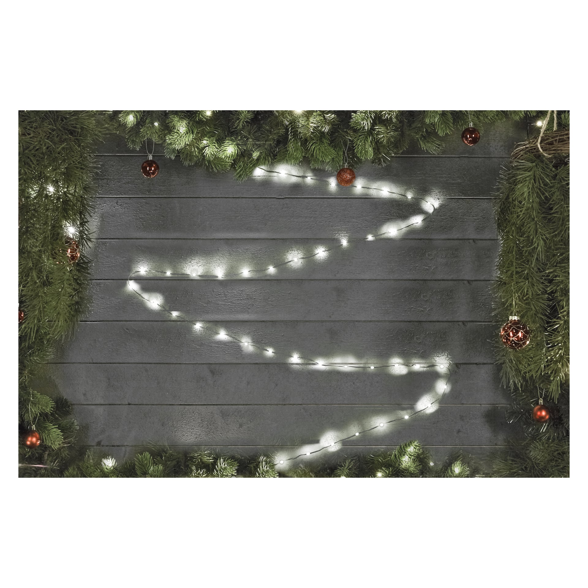 EKVIP LED-ljusslingor är arrangerade i ett sicksackmönster för att likna en julgran på en mörk trävägg, med gröna tallgirlanger och röda ornament som ramar in konturen.