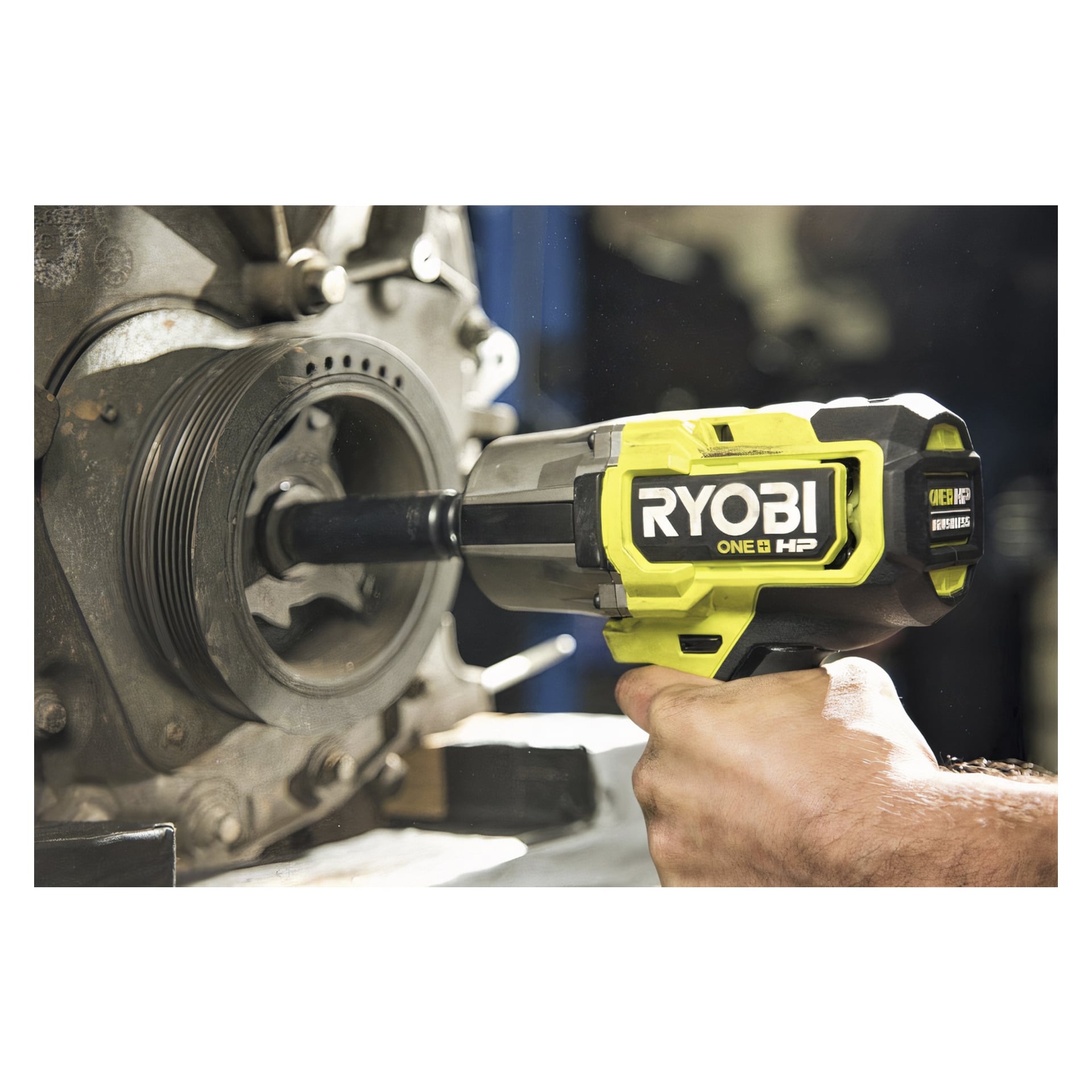 Ktoś obsługuje klucz udarowy Ryobi One+ HP zasilany baterią RIWH18X-0, dokręcając lub luzując śrubę w dużym elemencie mechanicznym, który może należeć do silnika lub podobnych maszyn.