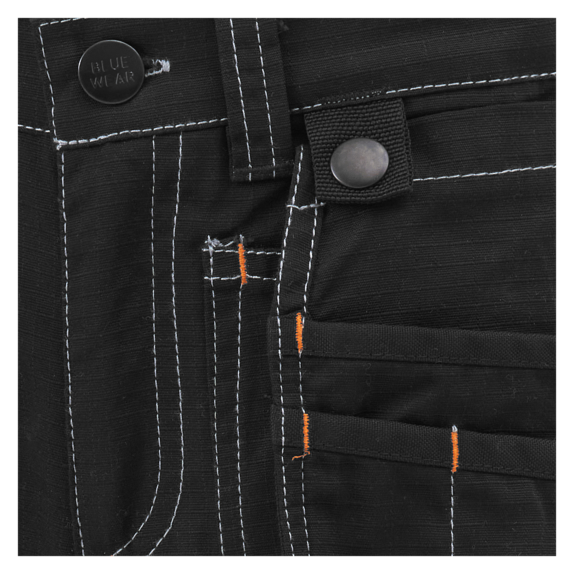 Detaljerad vy av Bluewears barns arbetsbyxor visar en ficka, bältesögla, knapp märkt med Bluewear-etiketten och synliga vita sömmar samt små orangea tråddetaljer nära ficksömmarna. Tygets och sömmens struktur visas i skarp detalj.