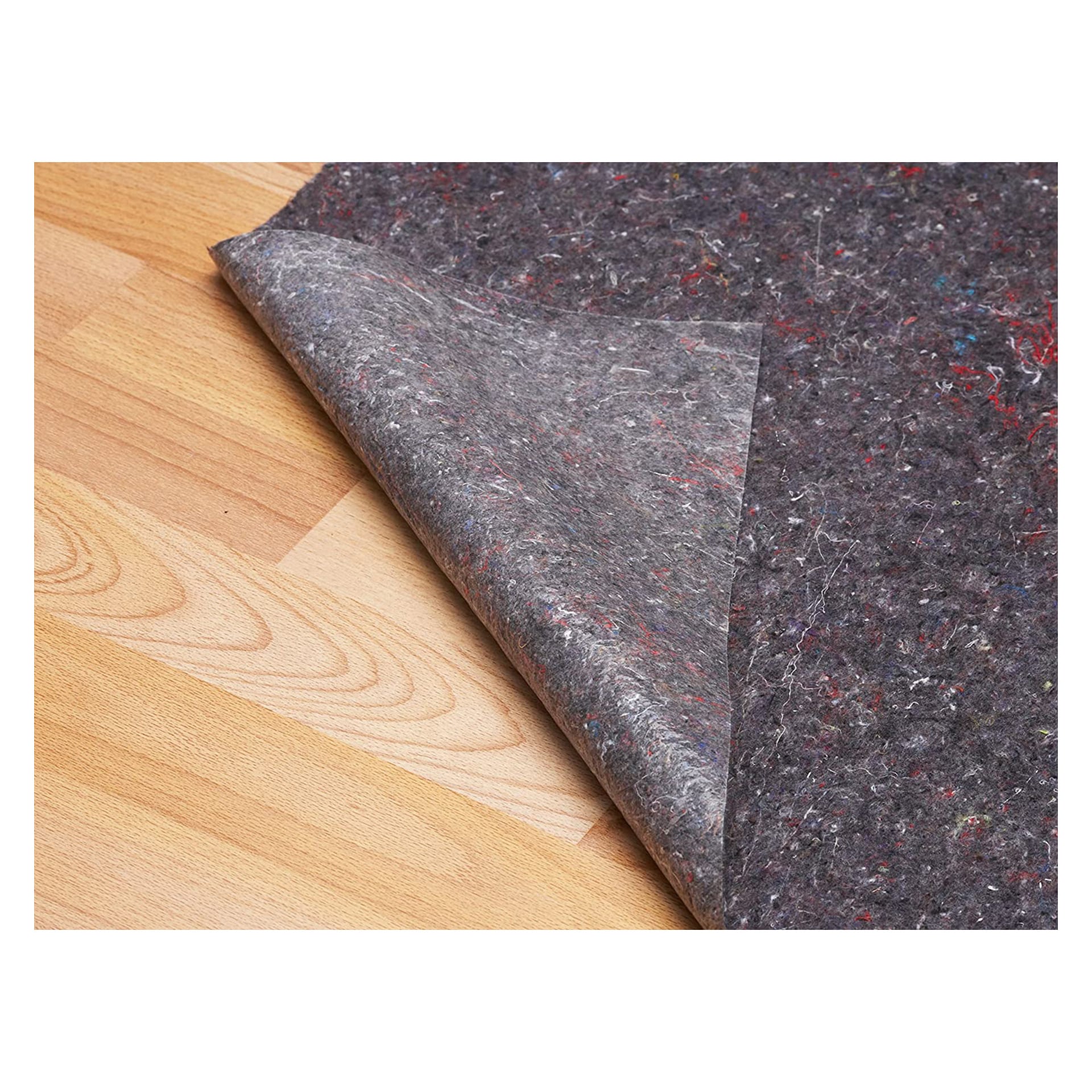 Eine Nahaufnahme zeigt eine Ecke der Hard Head Painting Matte, die angehoben wird und den hellen Holzboden darunter freilegt. Die graue Matte hat eine gefleckte Oberfläche mit sichtbaren farbigen Fasern.