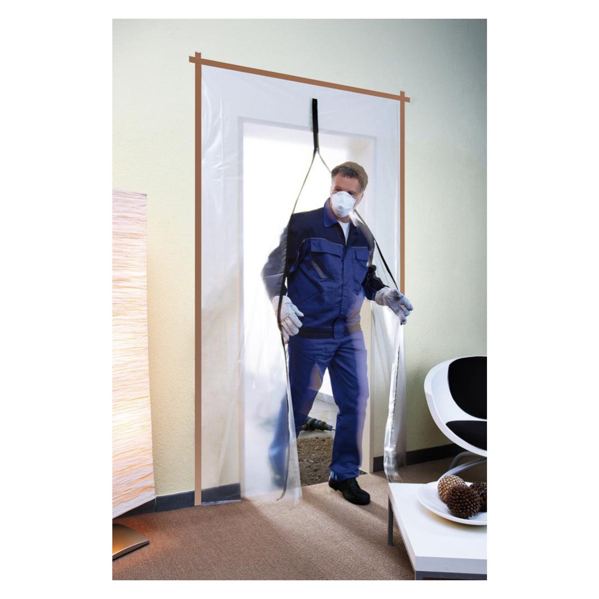 En man i ansiktsmask, handskar och blå overall går genom en Hard Head Separating Door draperad med transparent plast i en modern inomhusmiljö med en stol och ett bord.