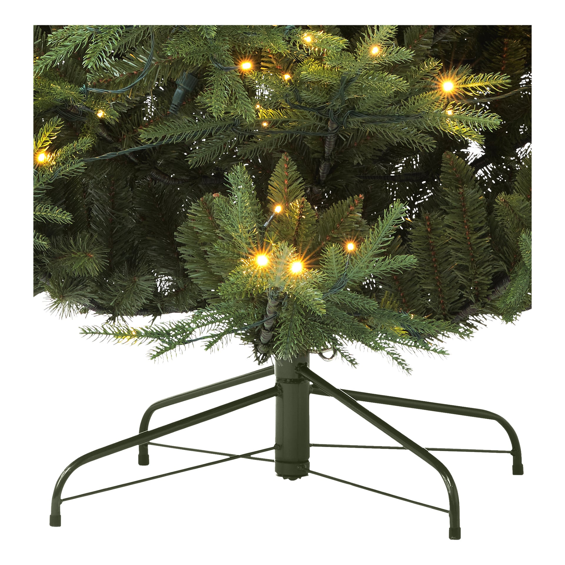 EKVIP Lifelike Christmas Christmas visas med naturligt utseende gröna grenar, lysande gula LED-lampor och en solid metallbas. Fotot fokuserar på den nedre delen av trädet och drar uppmärksamheten till stativet och de starkt upplysta grenarna.