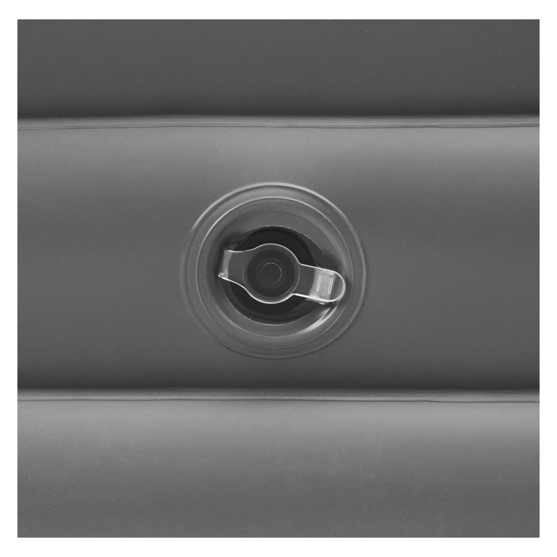 Detaljerad vy av en svart cirkulär luftventil med dess lock, placerad i mitten av den grå uppblåsta ytan på EKVIP Inflatable Bathtub. Ytan är utformad med horisontella upphöjda åsar.