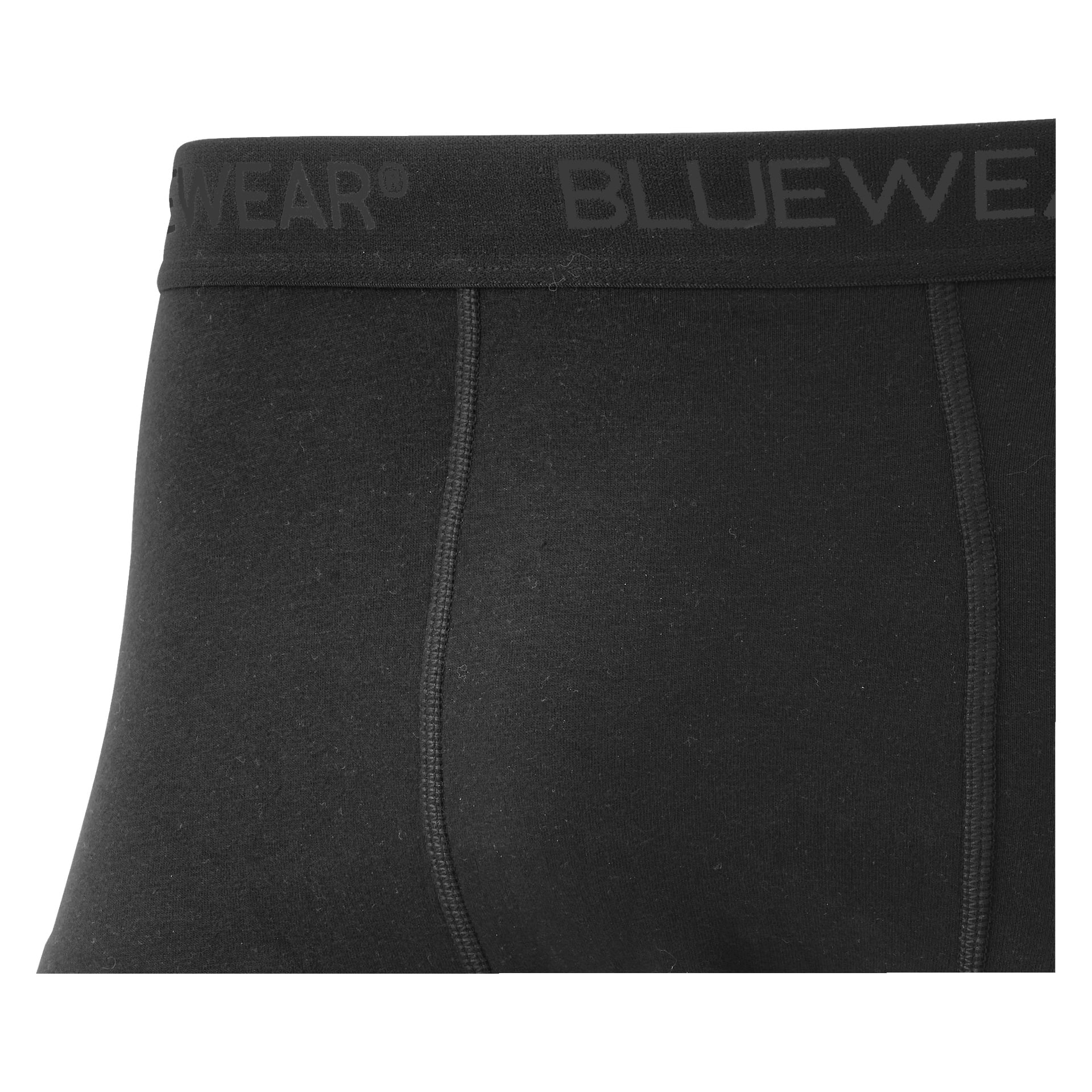 En närbild av den övre delen av en svart Bluewear-boxershorts från ett 5-pack set som framhäver de synliga sömmen och det svarta elastiska midjebandet med "BLUEWEAR" i grå bokstäver. Den enkla designen sticker ut mot en enkel bakgrund.