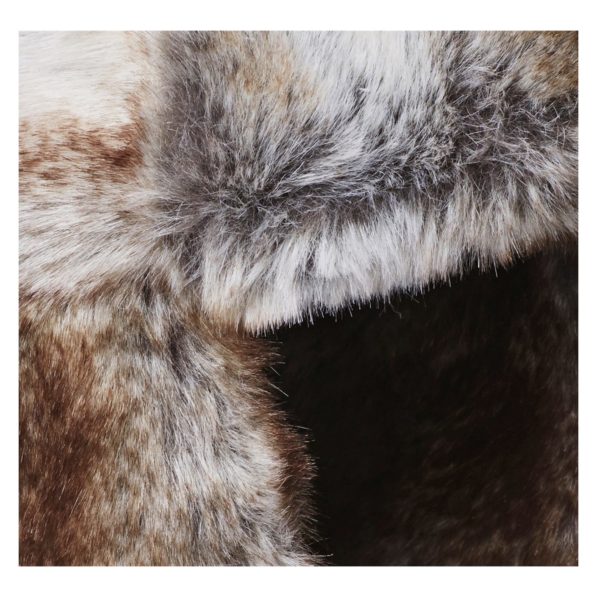 Detaljerad närbild av den tjocka, fluffiga djurpälsen på Kayoba Outdoor Fur Hat, som framhäver dess mjuka känsla och blandning av bruna, vita och gråtoner med tydliga ljusa och mörka områden.
