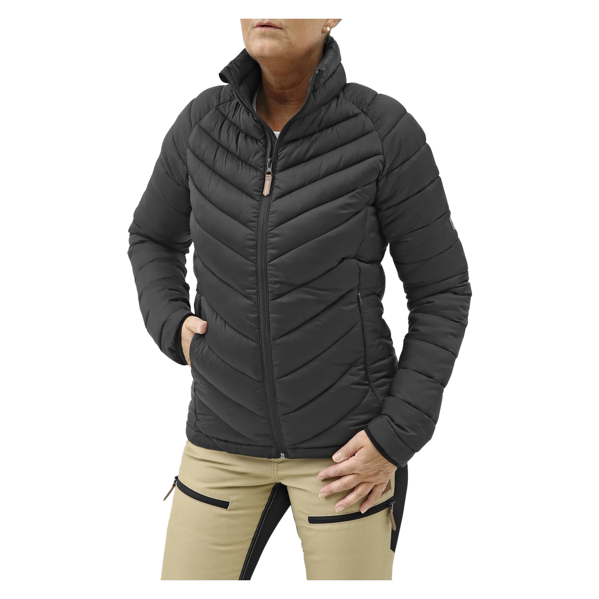 Någon visar Kayoba Outdoor Women's lättviktsjacka i svart, som har ett quiltat mönster och hög krage. De bär också beige byxor med svarta sidopaneler och har händerna nedstoppade i jackfickorna.