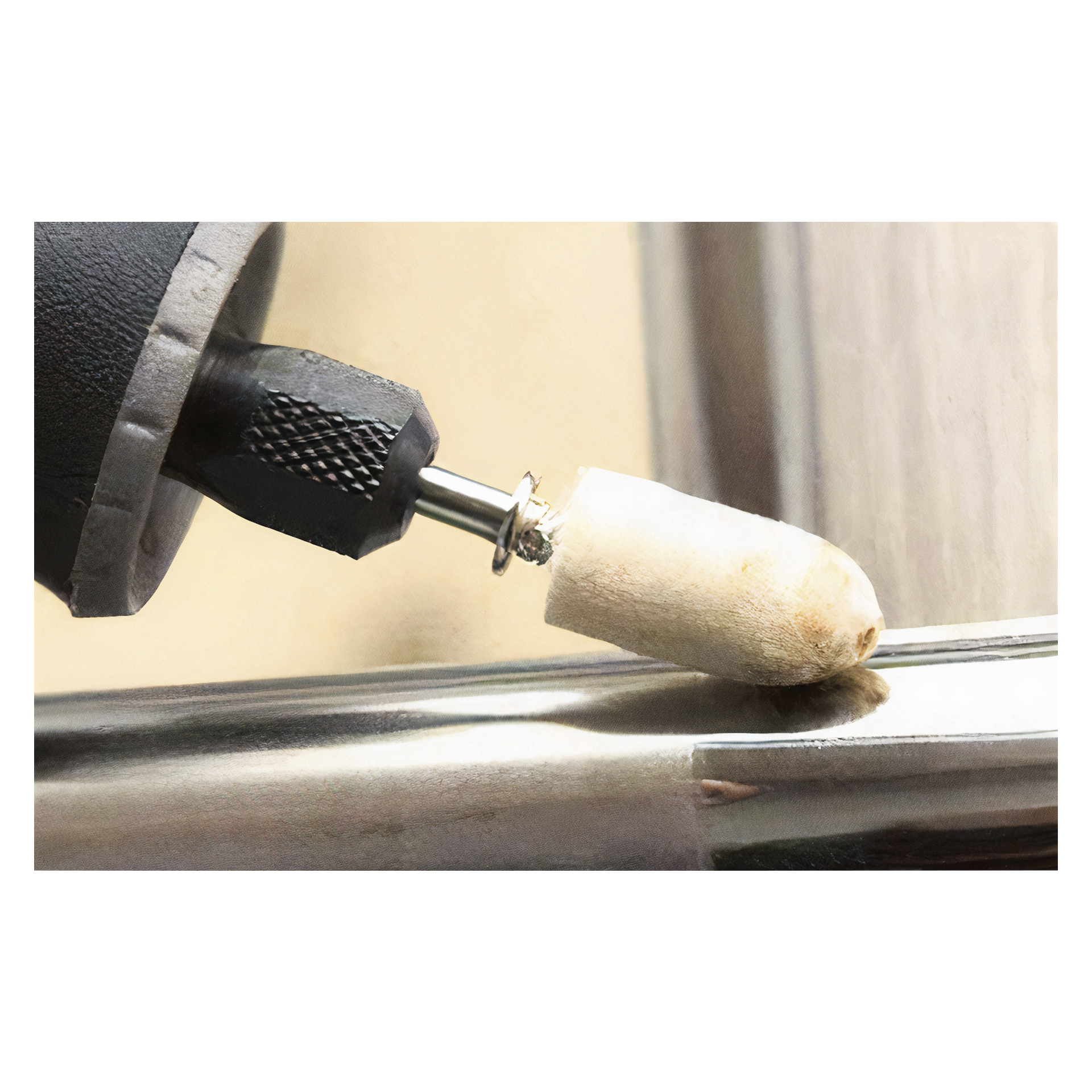 En detaljerad vy av Meec Tools Slip- och gravyrset 100 stycken i aktion, med en cylindrisk poleringsanordning som jämnar ut kanten på en reflekterande metallyta.