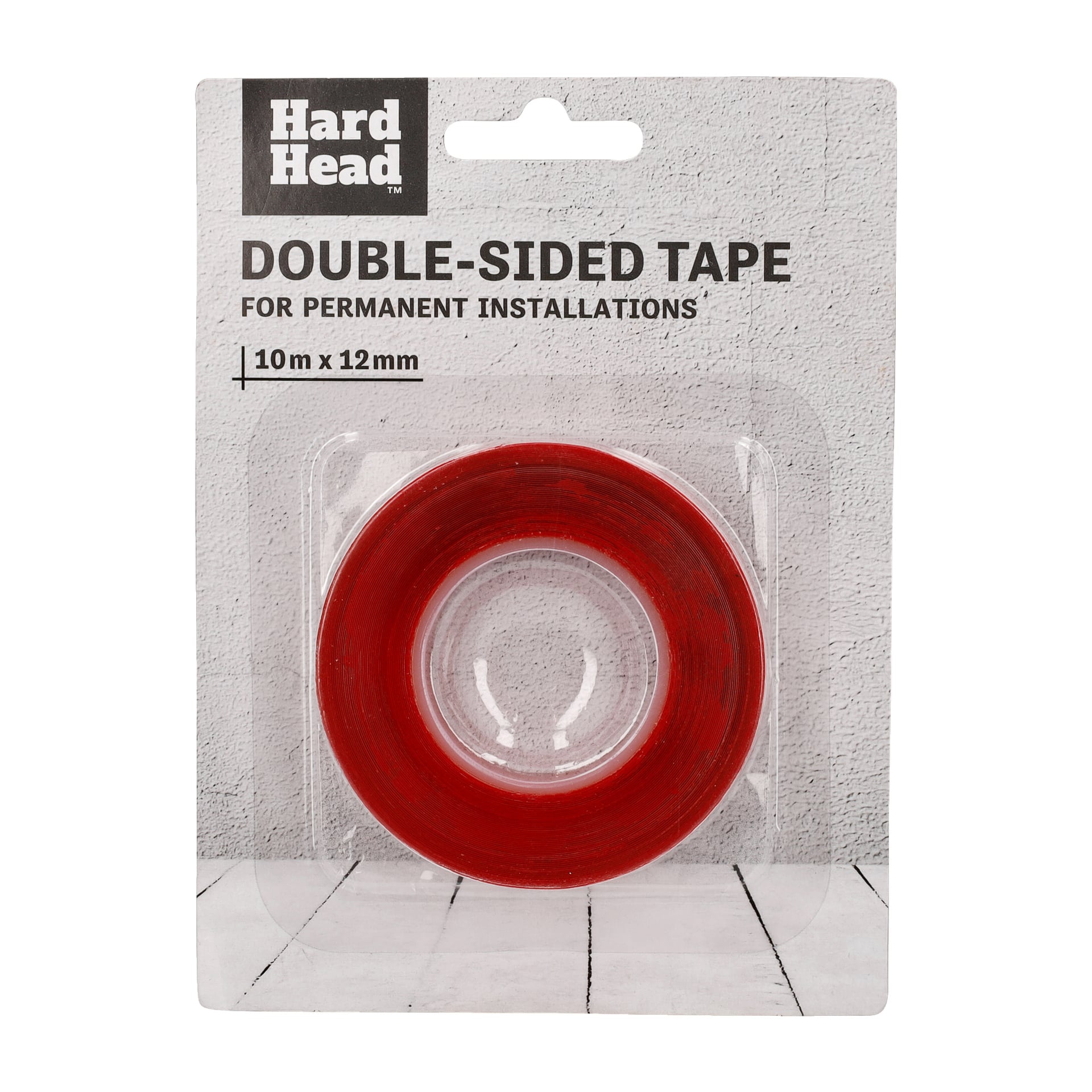 En rulle Hard Head dubbelsidigt tejp för permanenta installationer, 10 meter lång och 12 millimeter bred, packas och visas på en lätt texturerad yta.