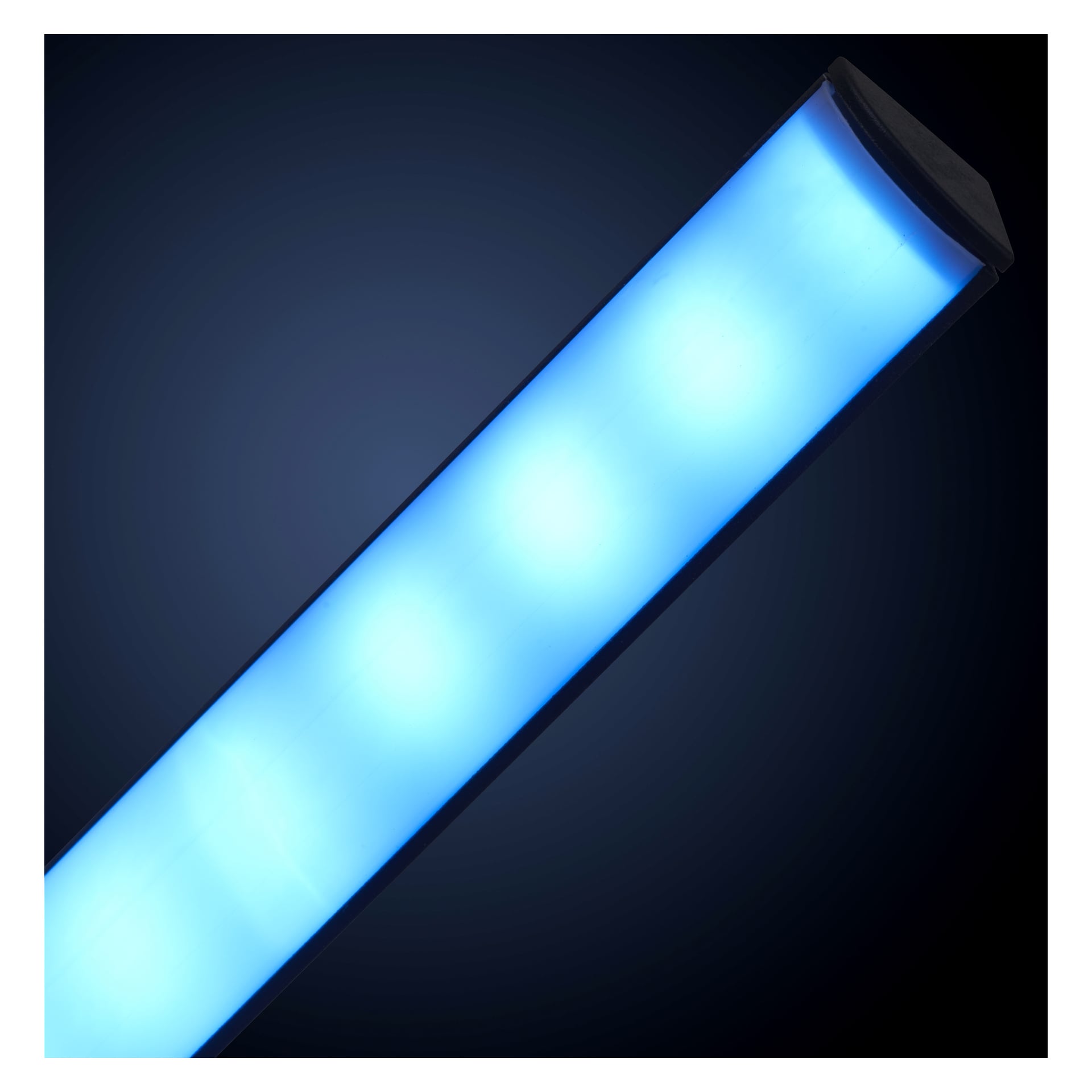 En slank EKVIP Floorlight LED sänder ut ett starkt blått ljus, mot en mörk bakgrund. Lampans rörformade, rektangulära form är placerad i en diagonal vinkel, med mjukt rundade ändar och jämn belysning längs hela armaturens längd.