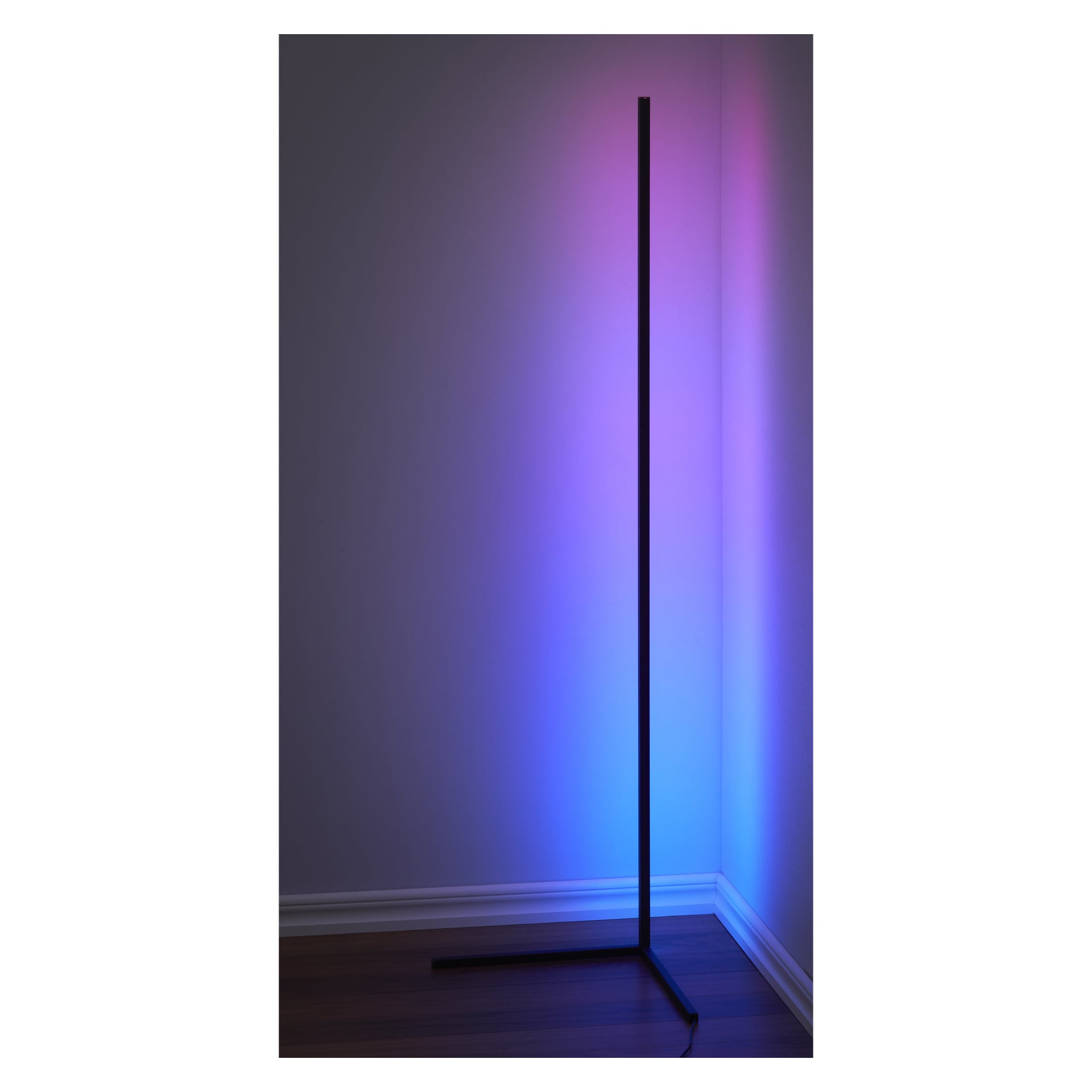 En smal, vertikal EKVIP Floor-lampa LED är placerad i hörnet och lyser upp de enkla väggarna och trägolvet med blått och rosa ljus medan den vita golvlisten löper längs nederkanten.