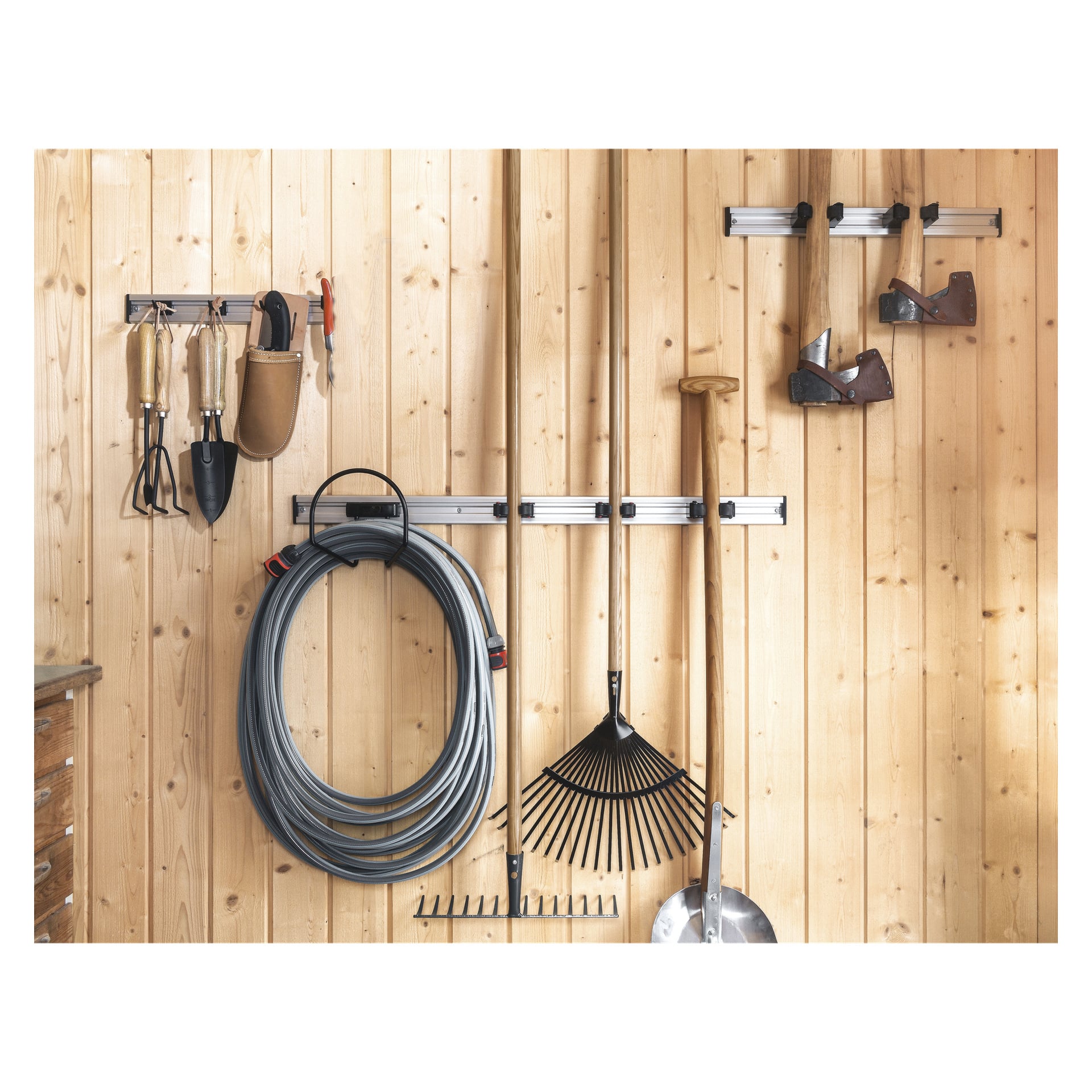Ett 2-pack Toolflex verktygshållare förvarar prydligt trädgårdsredskap, spadar, handverktyg, en slang och yxor på väggmonterade ställ fästa på en lätt träpanelad vägg.