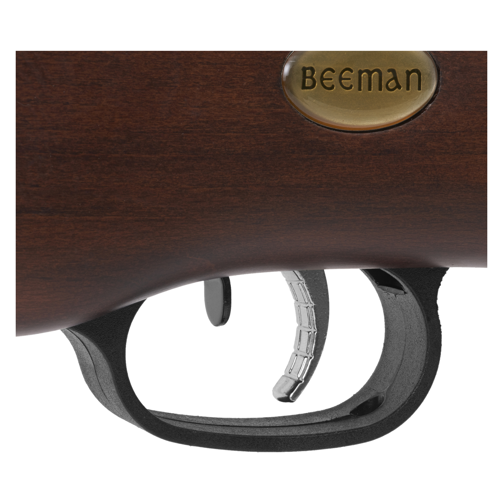Detaljerad vy av avtryckaren och avtryckarskyddet på ett Beeman RS2 luftgevär med en polerad brun träkolv, som visar ett ovalt emblem i mässing prydd med "Beeman.