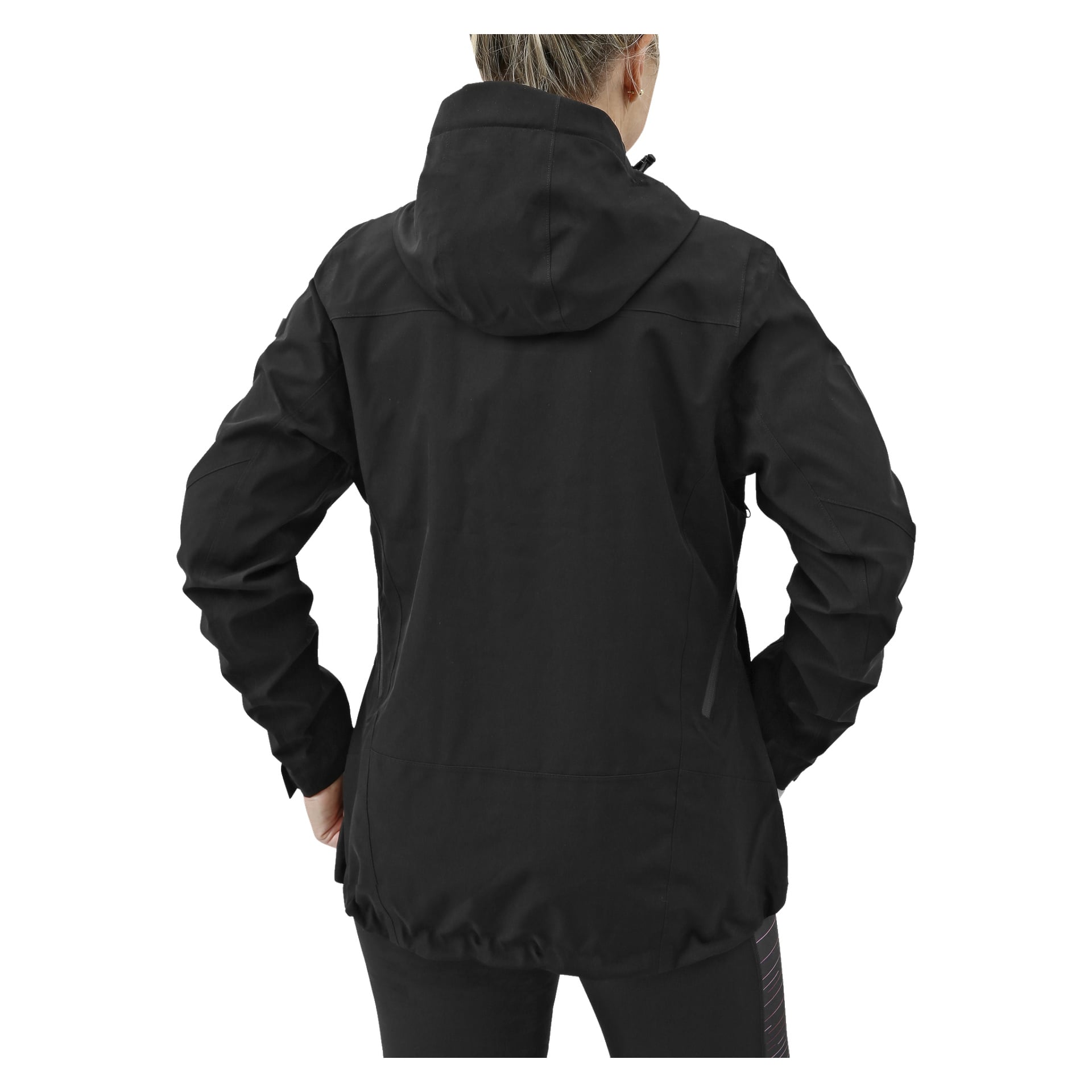 En person ses bakifrån med händerna på höfterna, klädd i svarta byxor och en svart Kayoba Outdoor Women's shelljacka som ser väderbeständig ut.