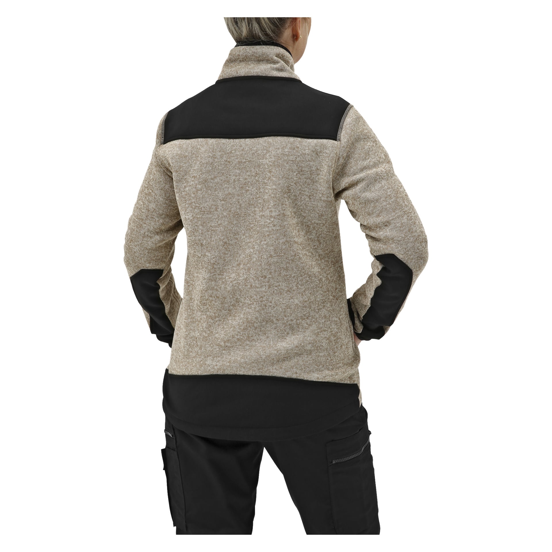 En person med kort hår står med händerna på höfterna, sedd bakifrån, iklädd en beige/svart fleecejacka för kvinnor från Bluewear och svarta cargobyxor.