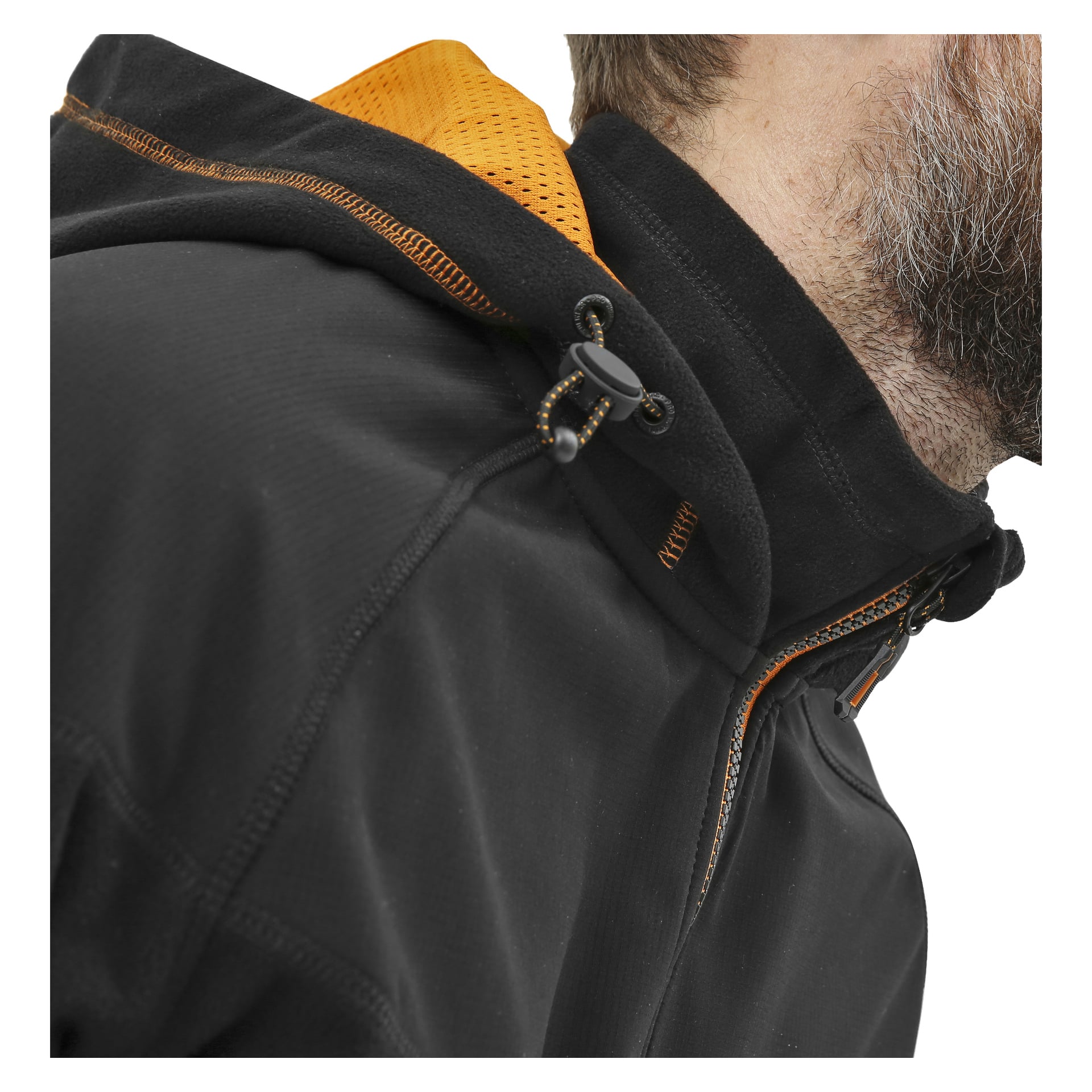 En närbild visar en person klädd i en svart Bluewear Pro Workwear herrjacka med vindtät fleecejacka med orange fodrad huva. Jackan har en dragkedja framtill och en justerbar dragsko med växlingsknapp. Personen har ett skägg, synligt från en del av ansiktet och övre bålen.