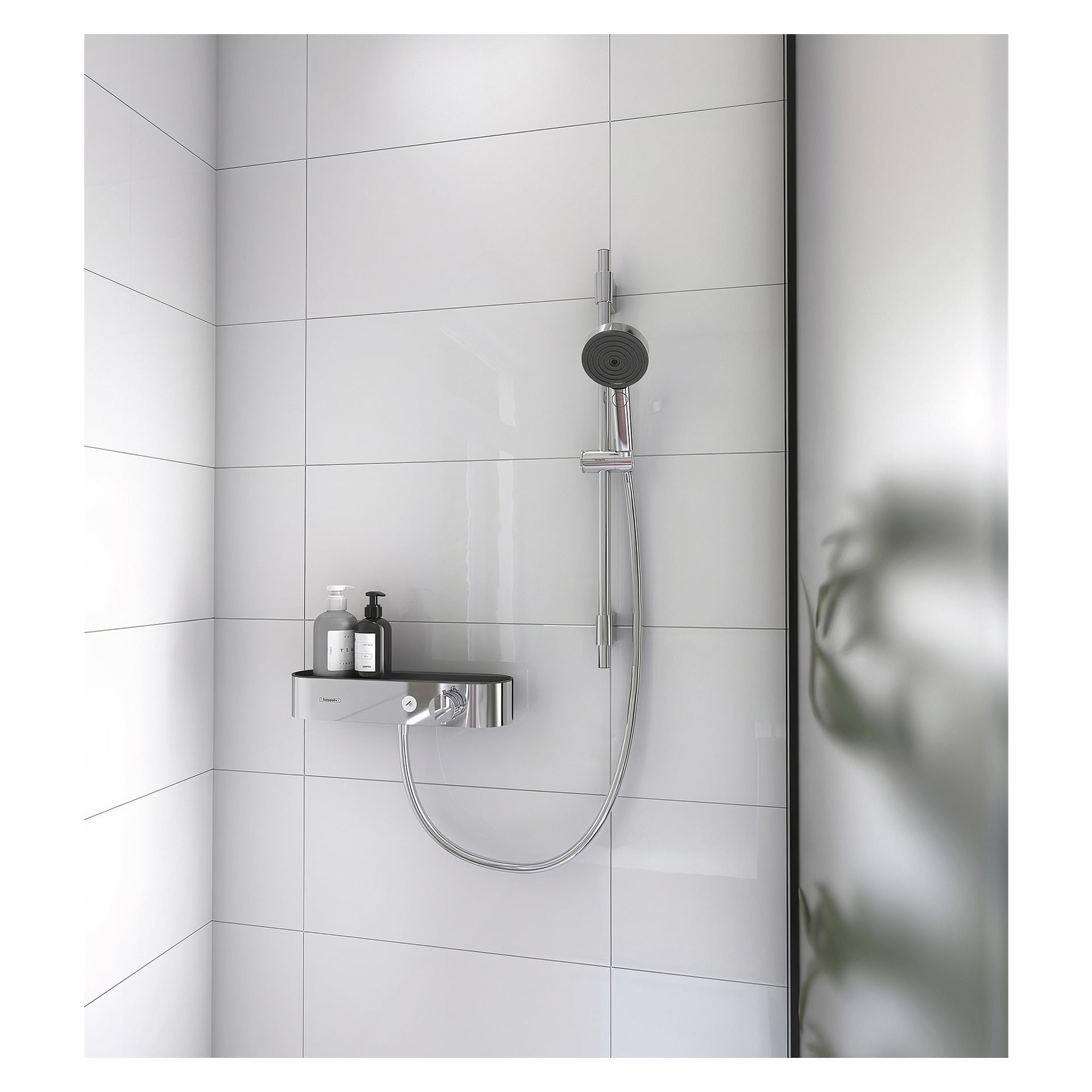 Hans Grohe dusjsett Pulsify Select S 105 3jet Relaxation EcoSmart vises med et krom håndholdt dusjhode på en stang, hylleoppbevaring og store hvite fliser i bakgrunnen. En grønn plante er delvis synlig i forgrunnen.