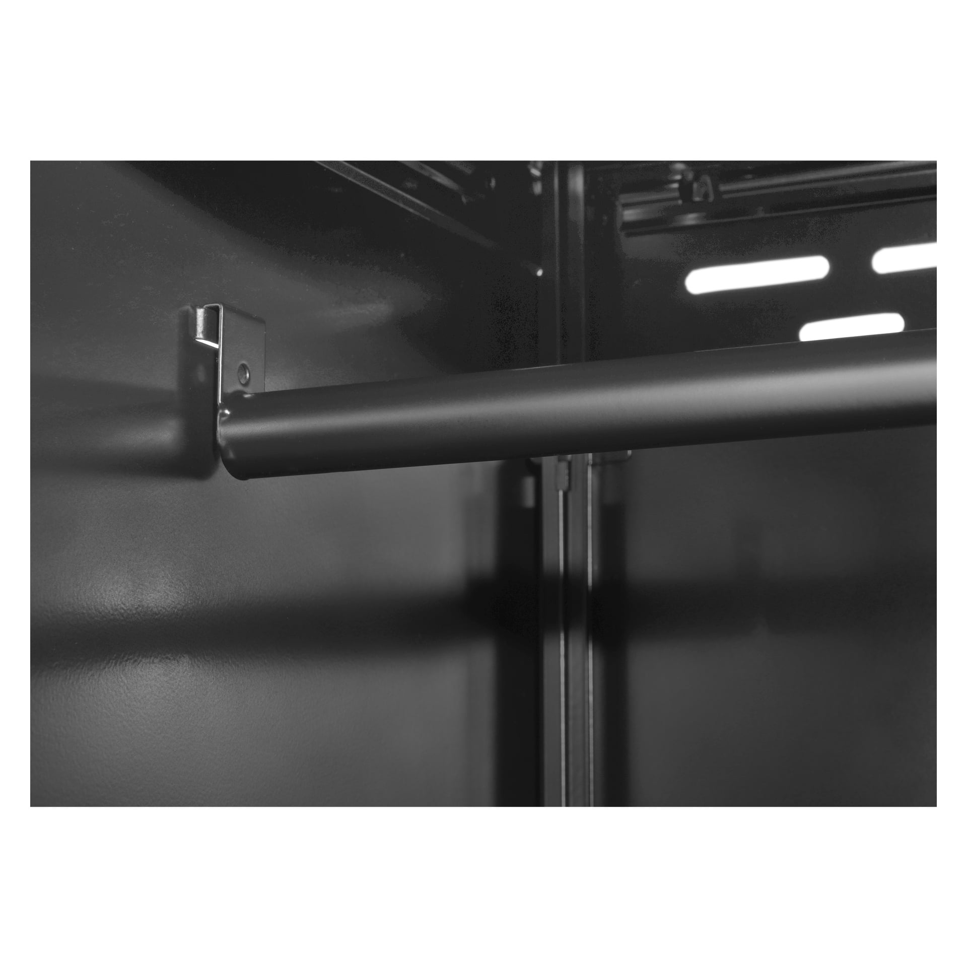 Svart-hvitt bilde av et Hard Head Storage-skap med to dører, stående tomt. Metallstangen er festet mellom sidene, og deler av innvendige vegger og ventilasjonsspor er synlige i bakgrunnen.