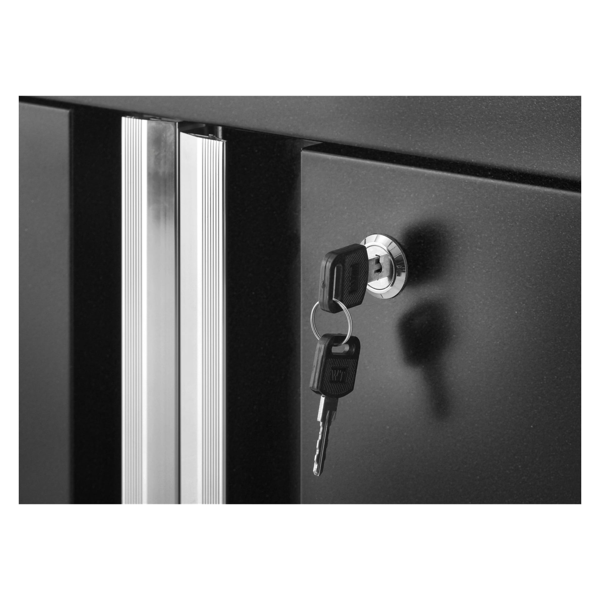 En närbild av Hard Head Tool-skåpet med två svarta dörrar har vertikala silverhandtag och ett centralt lås som håller ett par nycklar förenade med en liten metallnyckelring.