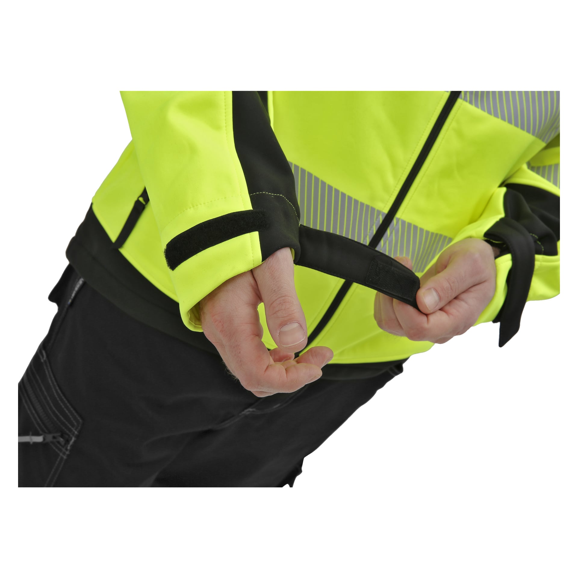 Någon ses justera kardborrebandet på ärmen på sin högsynliga gula Bluewear Hi-Vis softshell-jacka Toronto. Endast armar och bål visas. Jackan har svarta detaljer och reflekterande ränder.